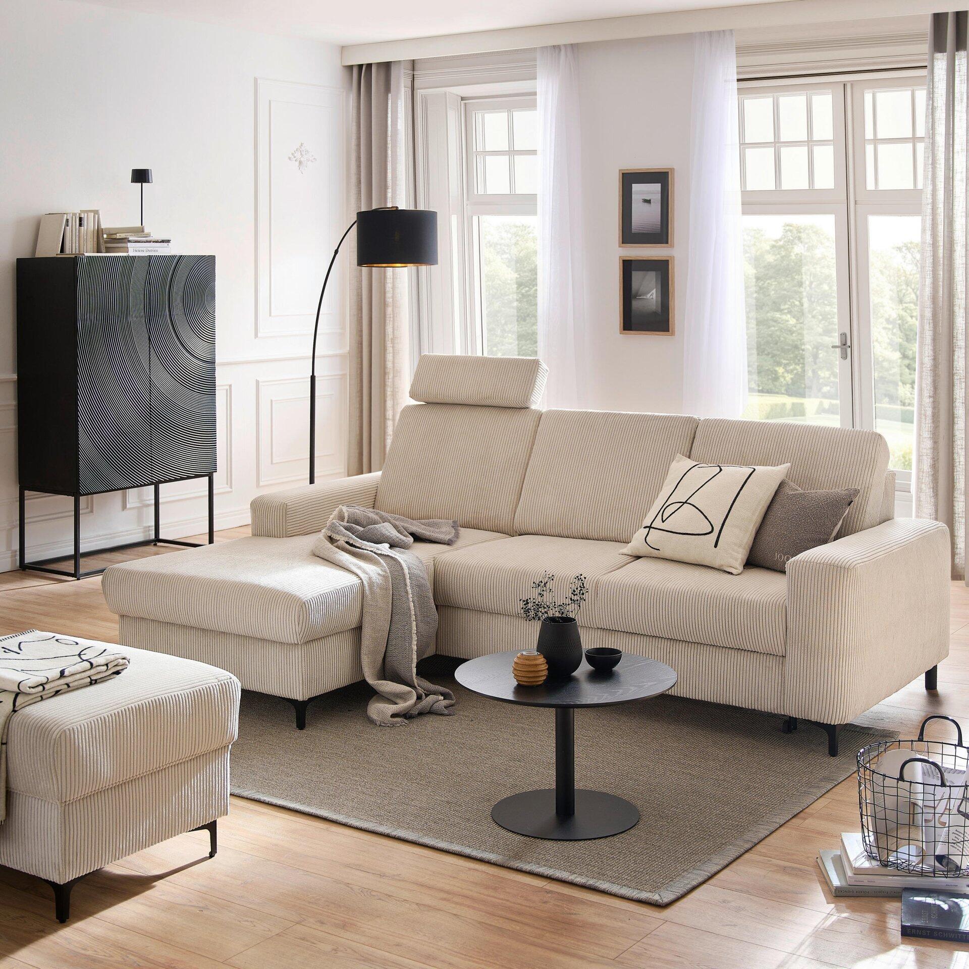 Ecksofa Balina mit Schlaffunktion und Ottomane, dargestellt in einer erhöhten Perspektive in einer hellen Wohnszene mit Blick in den Garten.
