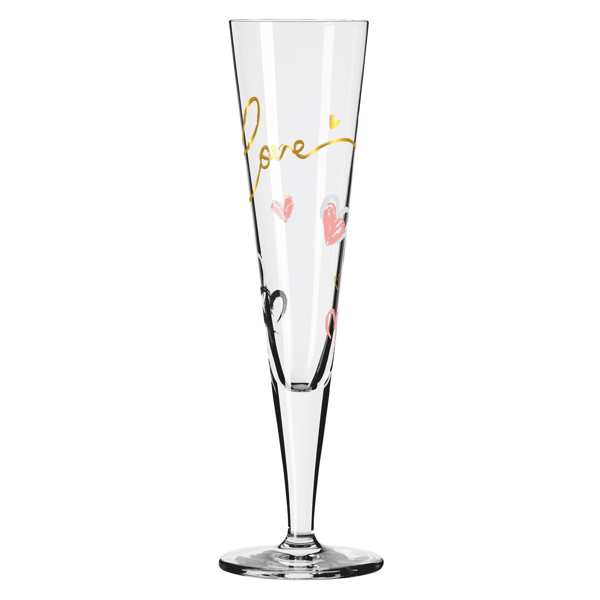 Nahaufnahme eines Champagnerglases aus der Seitenperspektive mit goldenen und rosafarbenen Herzchen-Motiven auf transparentem Glas, Teil eines Champagnerglas-Sets in Geschenkbox.