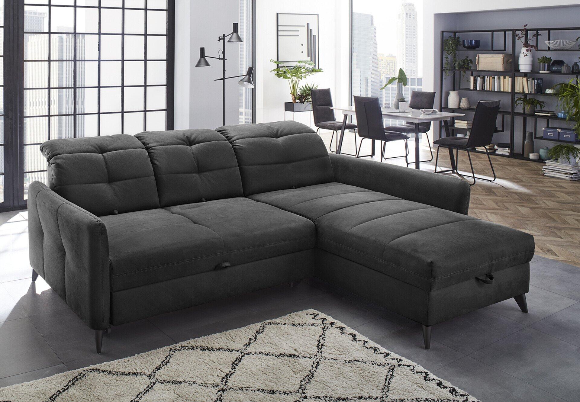 Wohnlandschaft Loft, graue Eckcouch mit herausziehbarem Schlafsofa, frontal aufgenommen und dominant im Raum platziert.