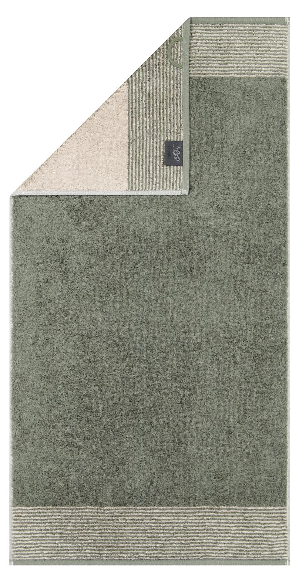 Waschhandschuh Two-Tone: Rechteckiges Baumwollhandtuch mit gerippter, olivgrüner Vorderseite und fein gerippter, beiger Rückseite sowie weißem Logo.