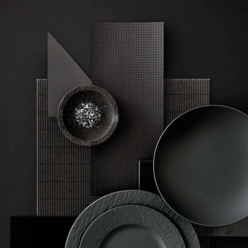 Schwarze, übereinander gestapelte Schalen der Serie Manufacture Rock mit schieferoptischer Textur und matter Glasur, inszeniert mit Schatteneffekten und dekorativen Elementen.