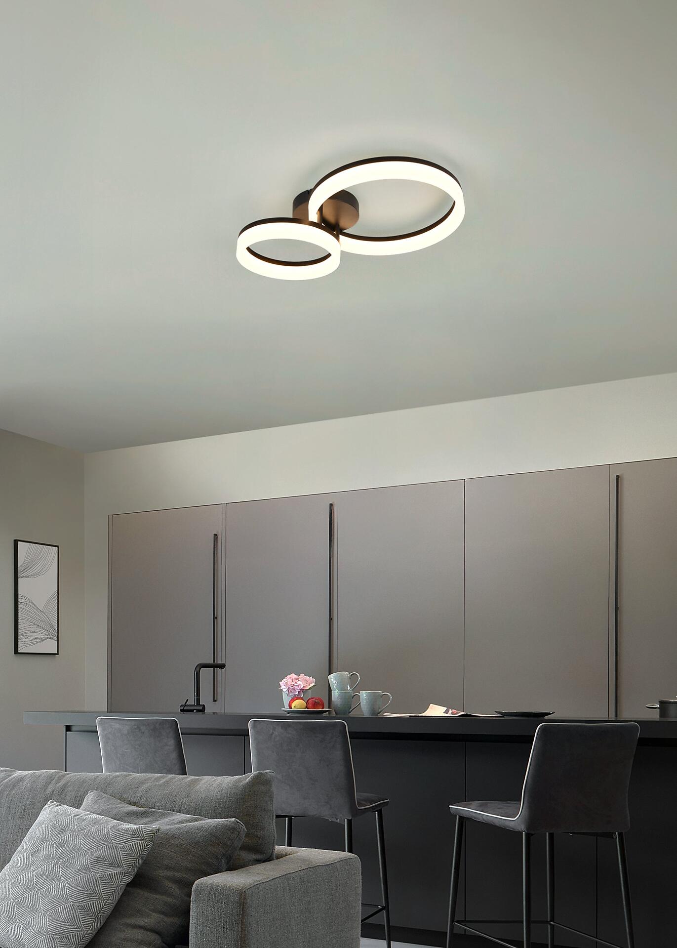 Deckenleuchte Scope mit drei kreisförmigen Lichtelementen, die einen modernen Akzent im Wohnzimmer setzt.