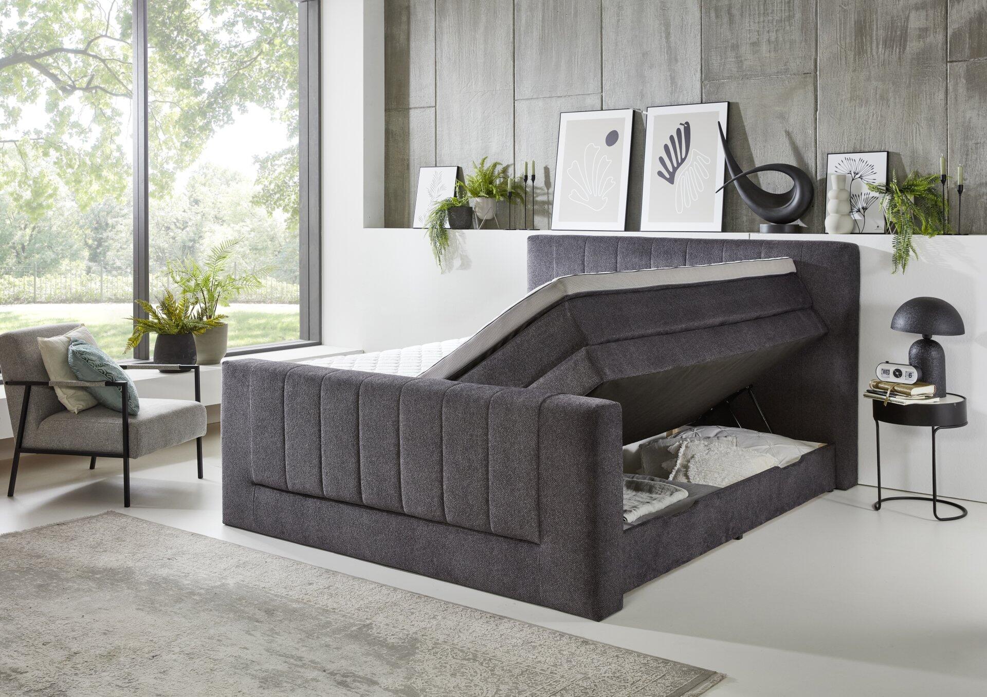 Boxspringbett Kenosha BX2450 mit grauem, gesteppten Kopfteil und aufgeklapptem Bettkasten zur Veranschaulichung des integrierten Stauraums.