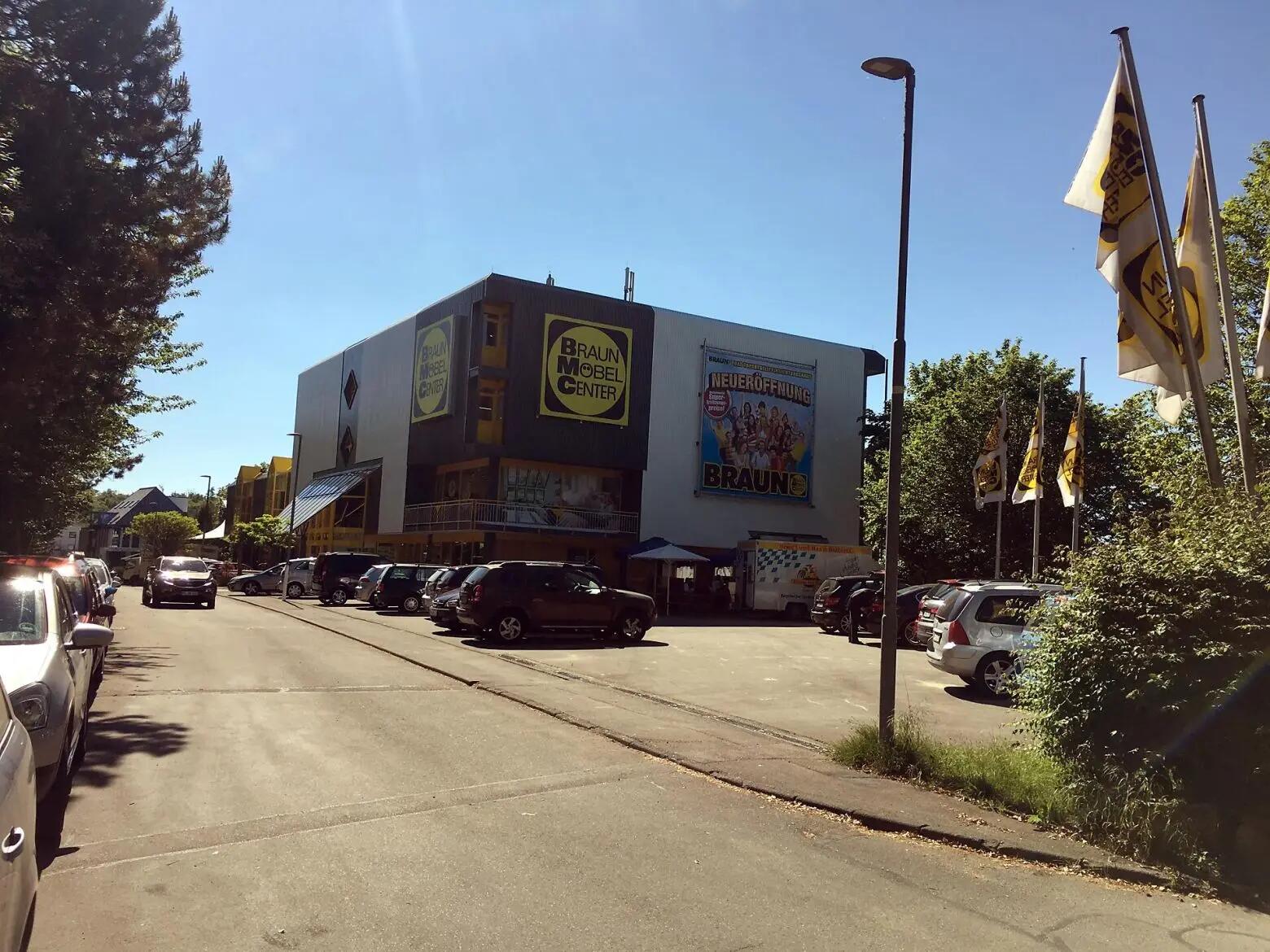 Braun Möbel Center Neueröffnung mit farbenfroher Fassade und Parkplatz.