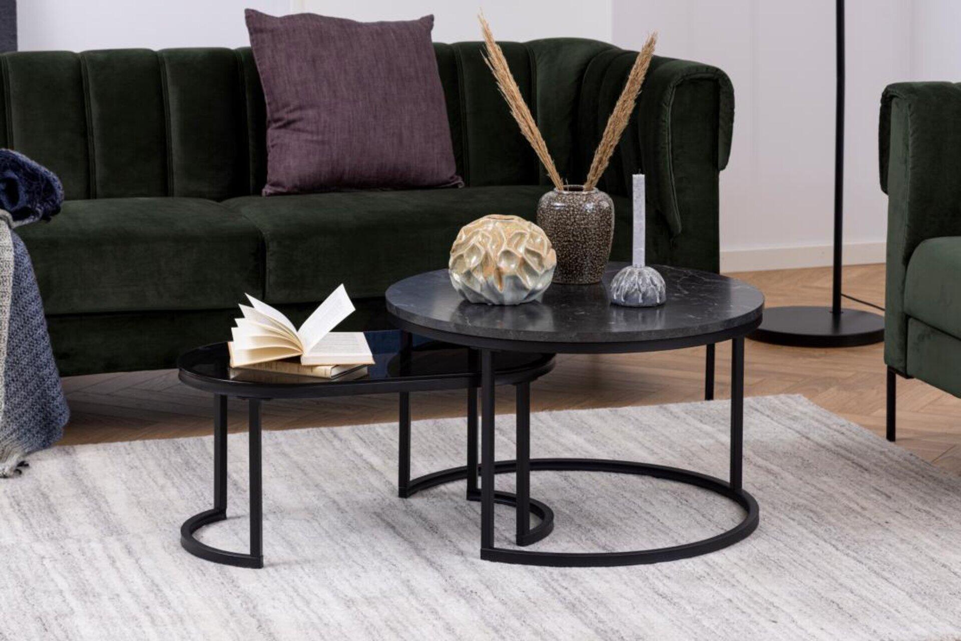 Couchtisch Spiro: Zwei runde Tische mit schwarzen Metallgestellen und Marmor-Optik, übereinandergestellt und mit dekorativen Elementen auf der oberen Tischplatte.