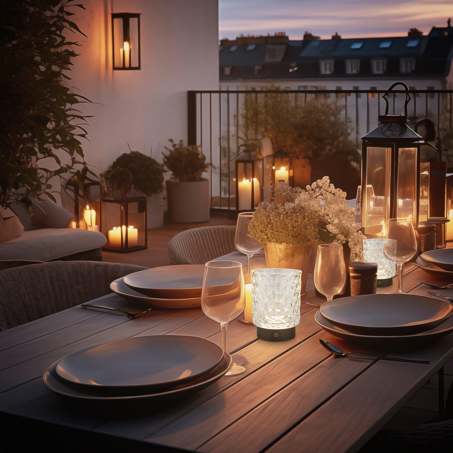 Tischleuchte Sunora mit Touchdimmer, die in einer Outdoor-Szene auf einem Esstisch platziert ist und eine stimmungsvolle Beleuchtung spendet.