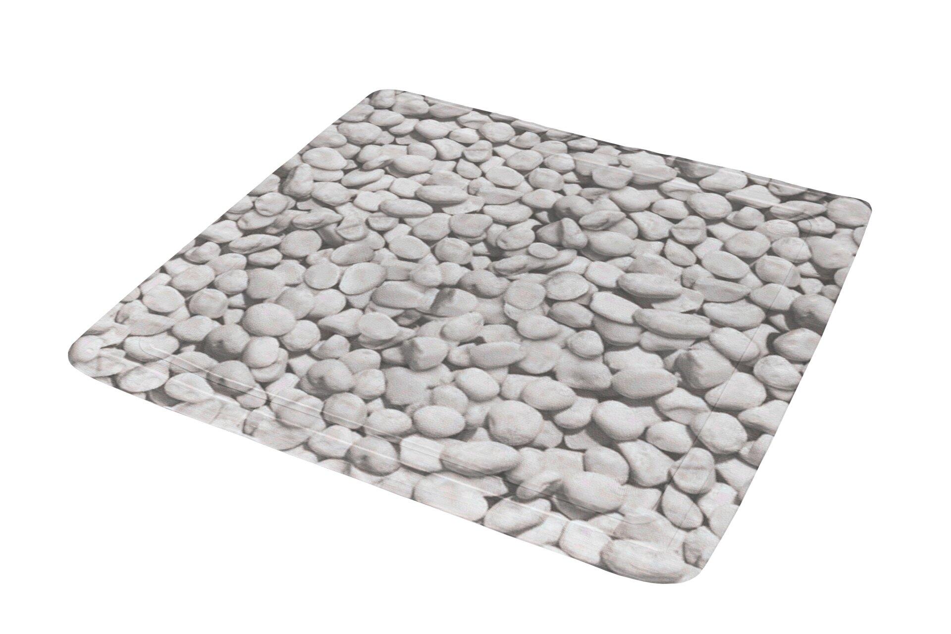 Duscheinlage Stepstone mit dekorativer, strukturierter Oberfläche aus hellgrauen Kieselsteinen, aus schräger Perspektive aufgenommen.