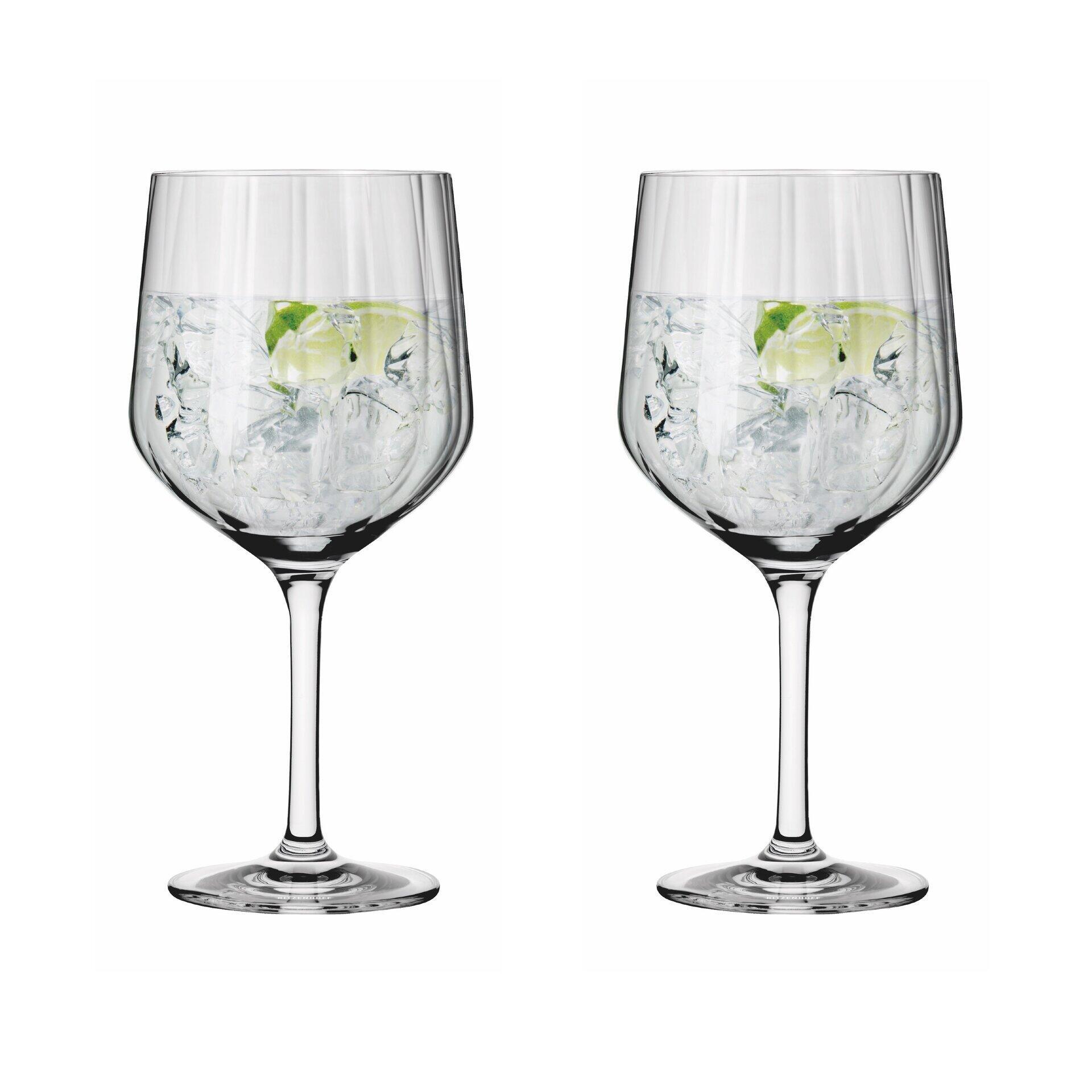Zwei Gin-Gläser mit Reliefstruktur, gefüllt mit Wasser, Eiswürfeln und Limette, auf weißem Hintergrund dargestellt.