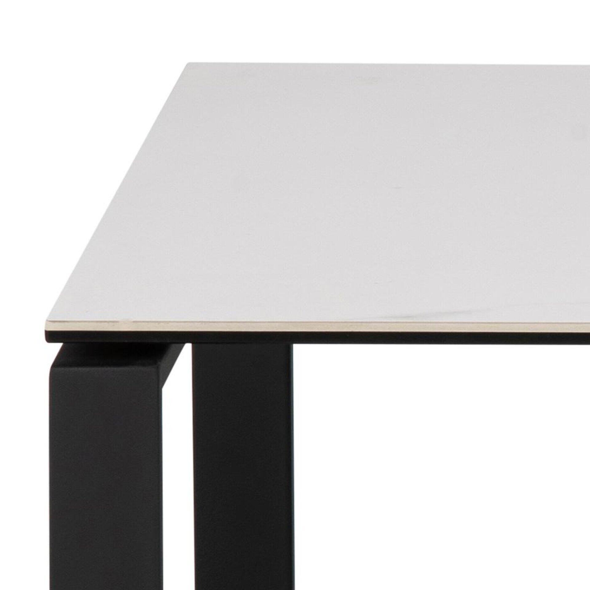 Detailaufnahme des Couchtisches Katrine: Weiße Tischplatte, die auf einem schwarzen Tischbein aufliegt, zeigt die Verbindung und die polierte Oberfläche.