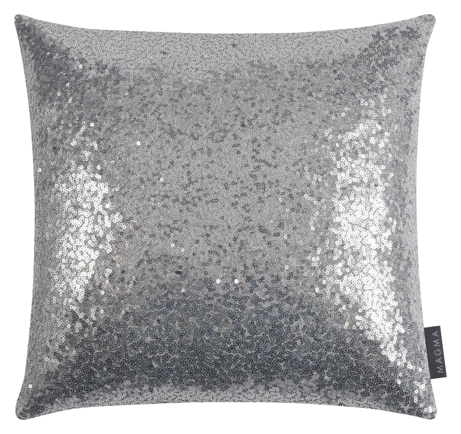 Glitzerndes Kissen mit silbernen Pailletten in sanftem Farbverlauf von dunkel nach hell, mit Reißverschluss und "MAGMA"-Etikett.