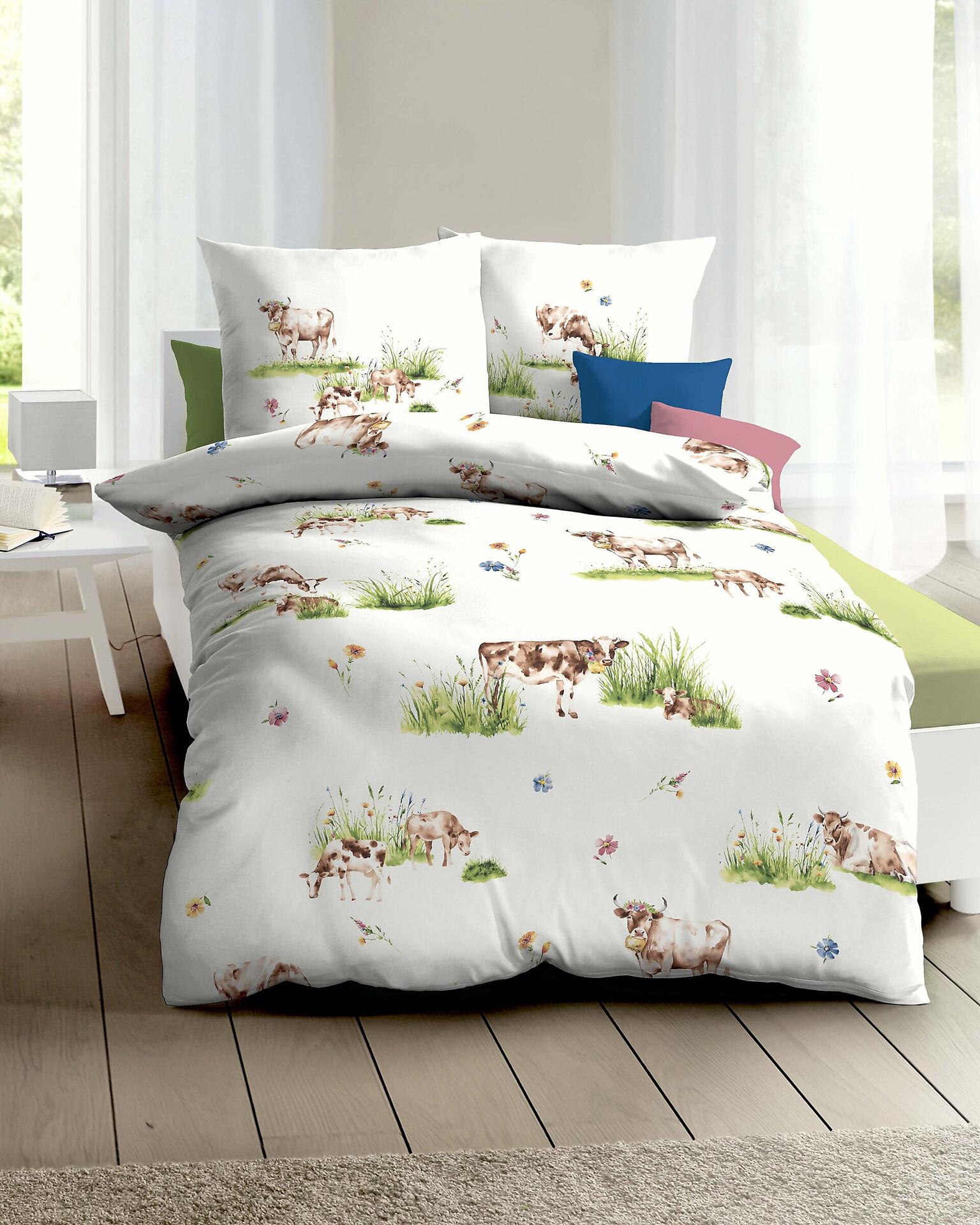 Bettwäsche-Set "Almauftrieb" mit grünem Design aus Kühen in einer grasbewachsenen Landschaft, aus der Vogelperspektive.