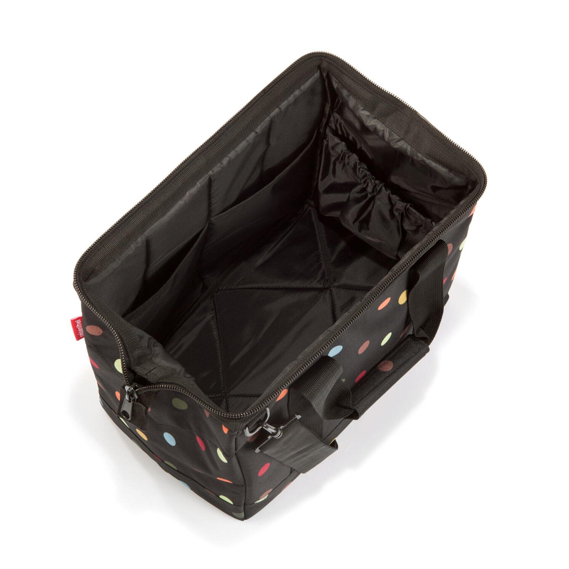 Aufgeschnittener Allrounder m Organizer mit farbigen Punkten auf schwarzem Hintergrund, der verschiedene Fächer, elastische Bänder und seitliche Reißverschlussfächer im Detail zeigt.