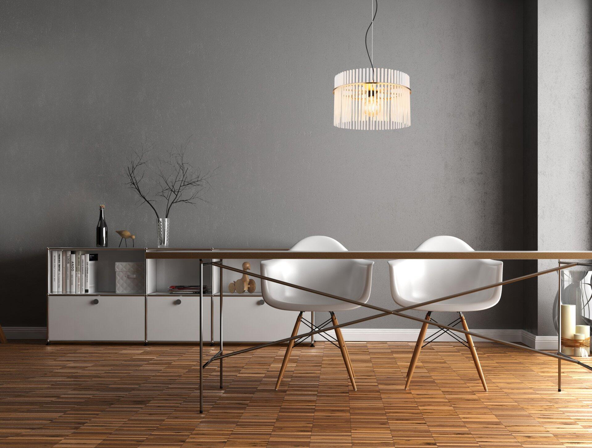 Pendelleuchte GORLEY mit verziertem Lampenschirm, die über zwei Stühle mit weißer Sitzfläche und schwarzen Metallbeinen hängt.