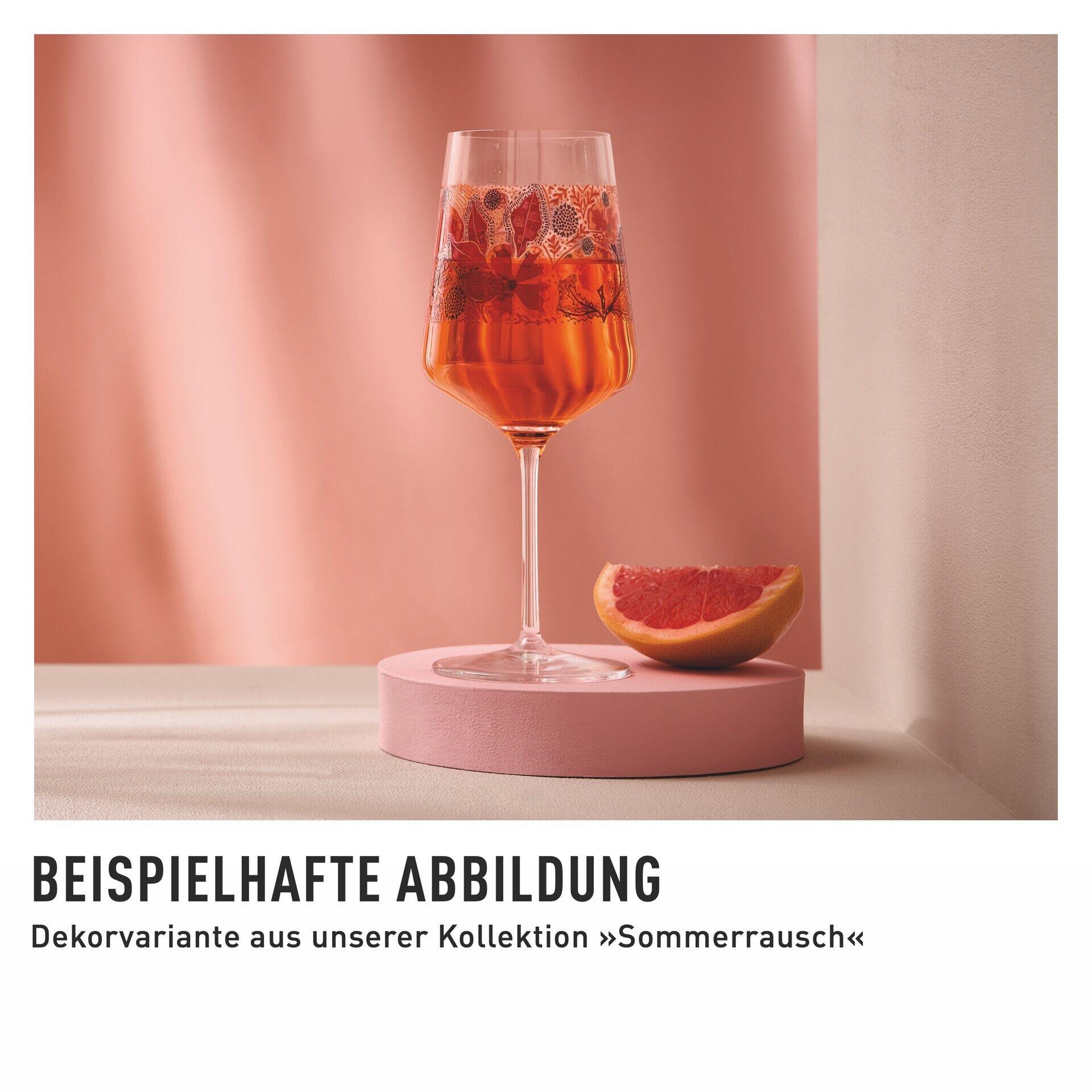 Dekoratives Aperitifglas auf Rosasockel, gefüllt mit perlendem Roséwein, neben einer halben Grapefruit, präsentiert in dynamischer Perspektive.