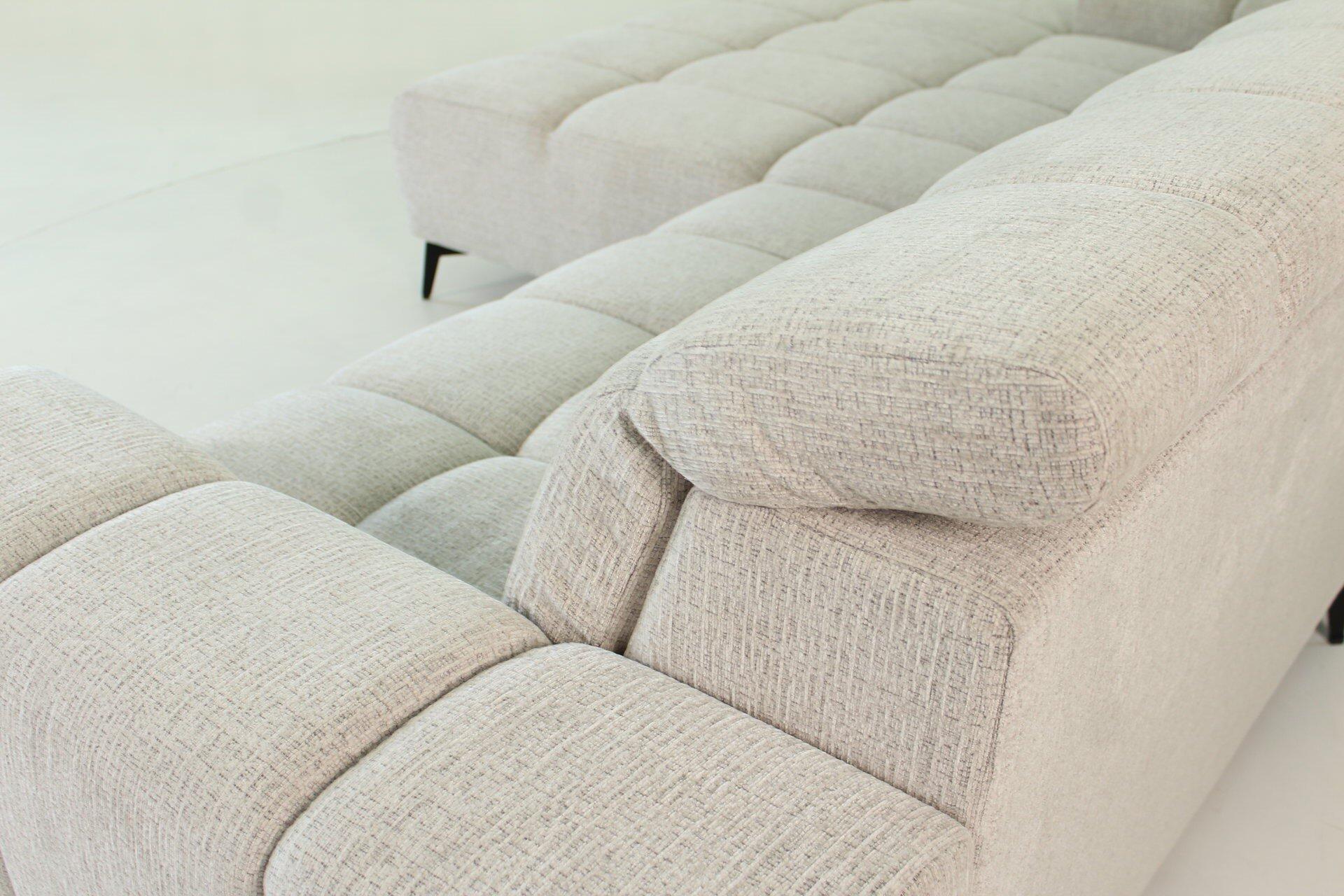 Nahaufnahme eines hellbeige Sofas der Polsterecke SCALLY mit breiten Kissen und abgerundeten Armlehnen, das die moderne Optik und die hochwertige Stofftextur betont.