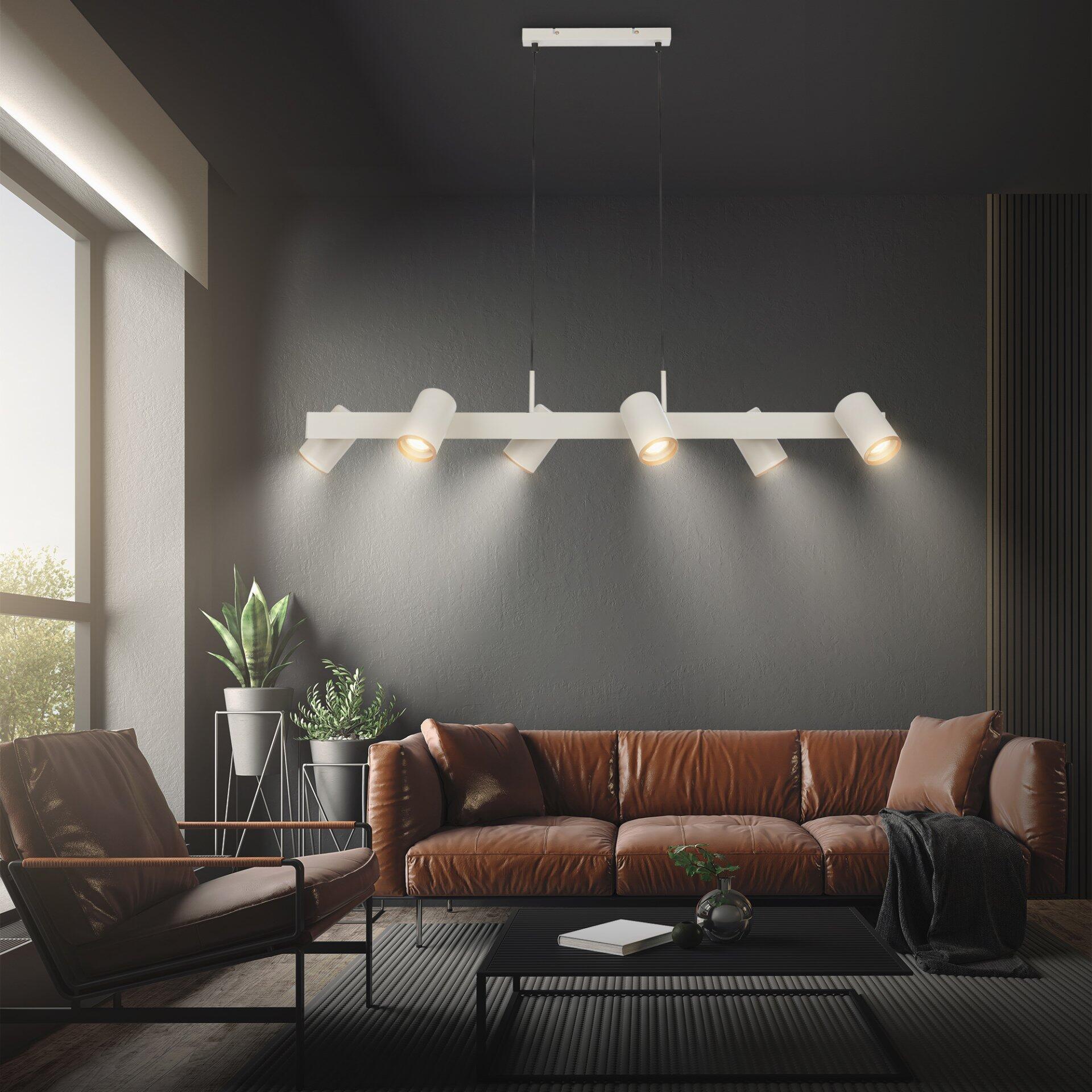 Pendelleuchte Era mit mehreren zylindrischen Lampenschirmen, die in einem modernen Wohnzimmer an der Wand befestigt ist und durch ihre Anordnung ein warmes, indirektes Licht erzeugt.
