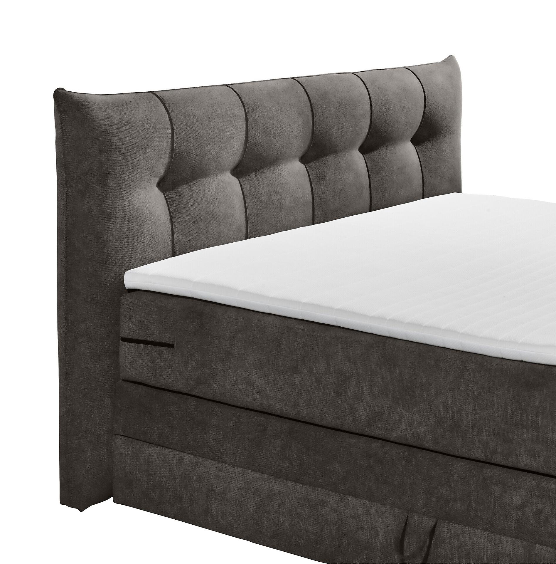 Boxspringbett Maracana 6 in Seitenansicht mit hochgestecktem Kopfteil, gepolsterten Kissen und integriertem Bettkasten für zusätzlichen Stauraum.