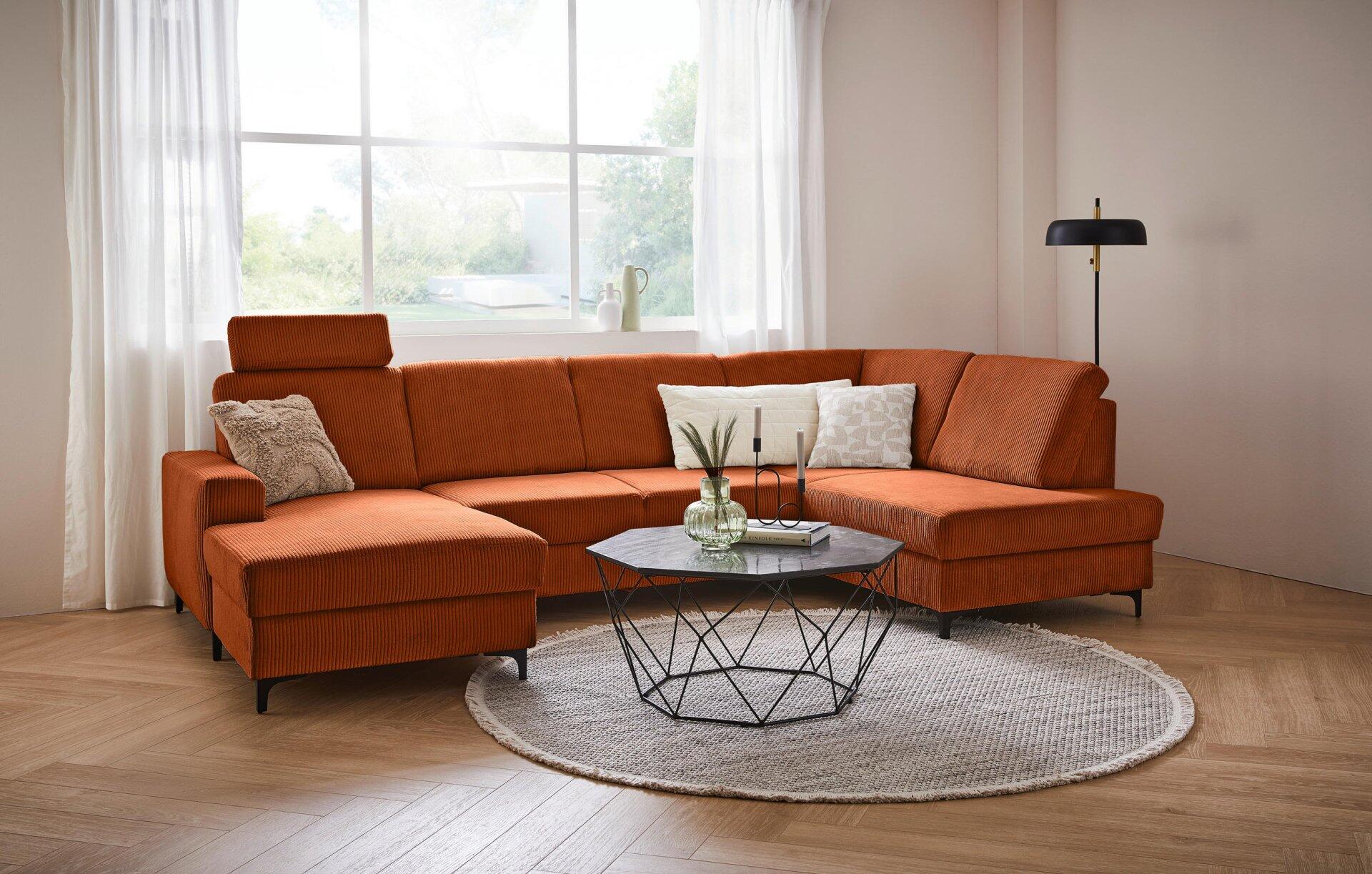 Wohnlandschaft Balina mit U-Form, gewellter Struktur, verstellbaren Kopfstützen und Bettkasten, aus erhöhter Perspektive im modernen Wohnzimmer.