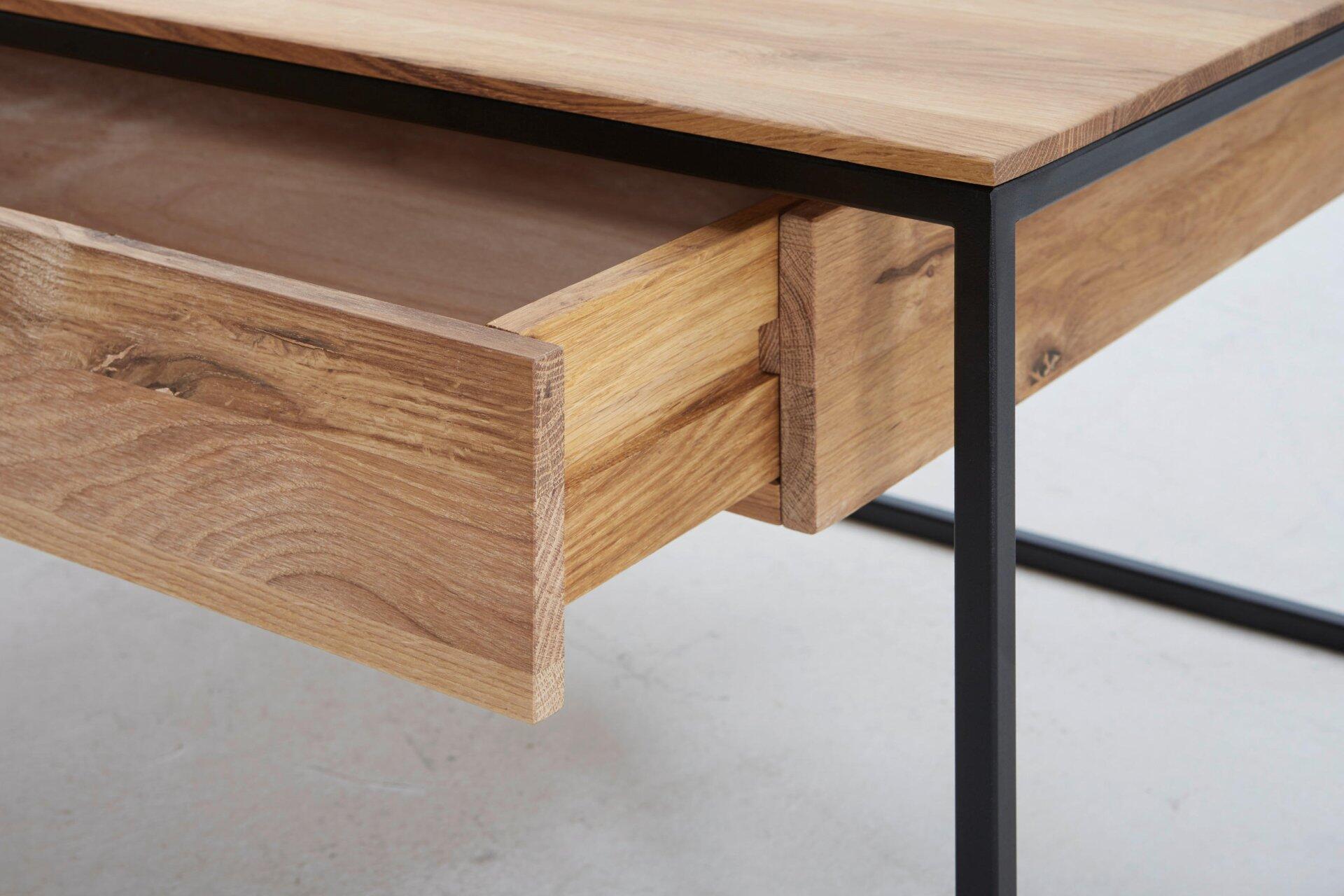 Detailaufnahme der ausziehbaren Schublade des Couchtisches Patricia mit hellem Holz, natürlicher Maserung und Führungsschienen im schwarzen Metallgestell.