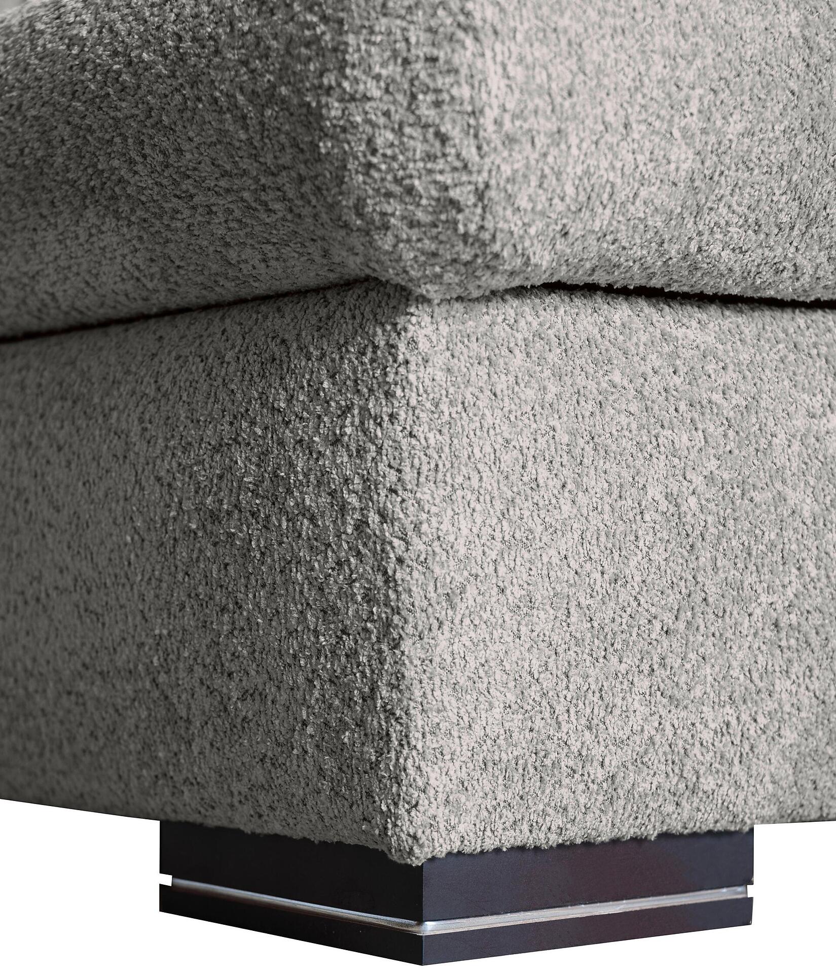 Detailaufnahme des Ecksofas Malmo: Grau bezogene Ecke mit abgerundeten Kanten und lackiertem, braunem Holzfuß mit silberner Kante und schwarzer Basis.