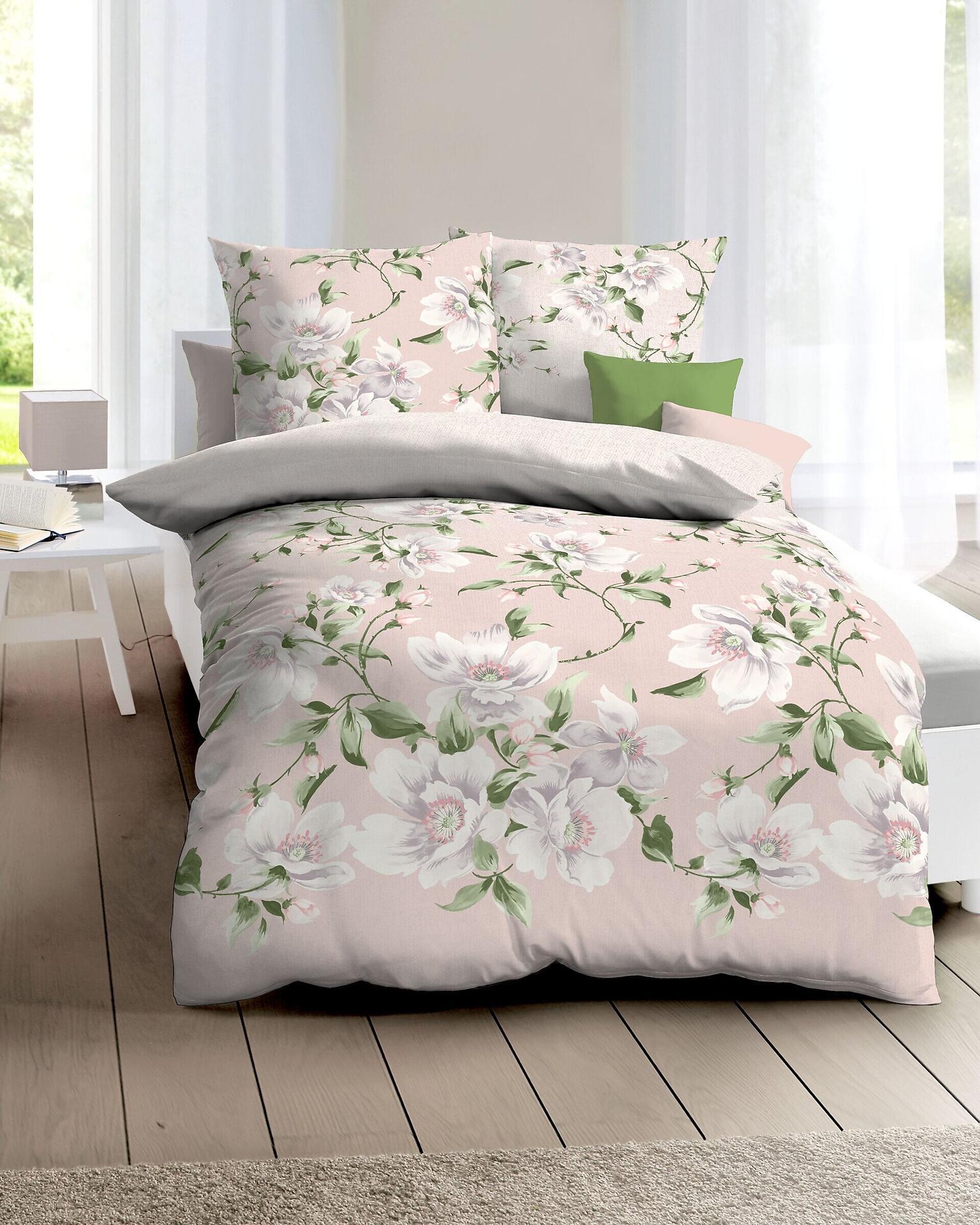 Roséfarbene Thealina Bettwäsche aus Satin-Baumwolle mit Rosenmuster auf hellrosa Bezug und hellgrauem Kissenbezug, Vogelperspektive auf einem Bett im hellgrauen Bettbezug.