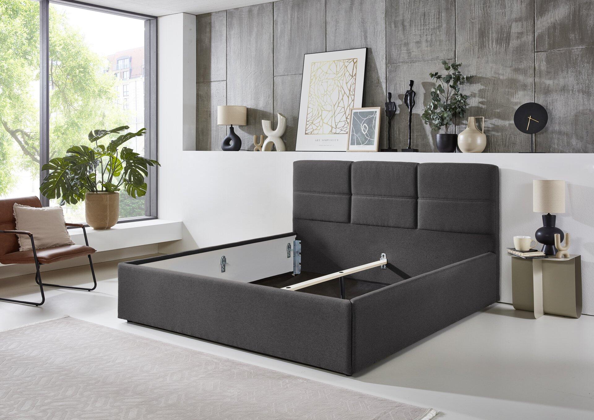 Polsterbett Durango PB100 in Grau mit gepolstertem Kopfteil und integrierter Schublade für zusätzlichen Stauraum, aus einer Vogel- und Frontansicht.