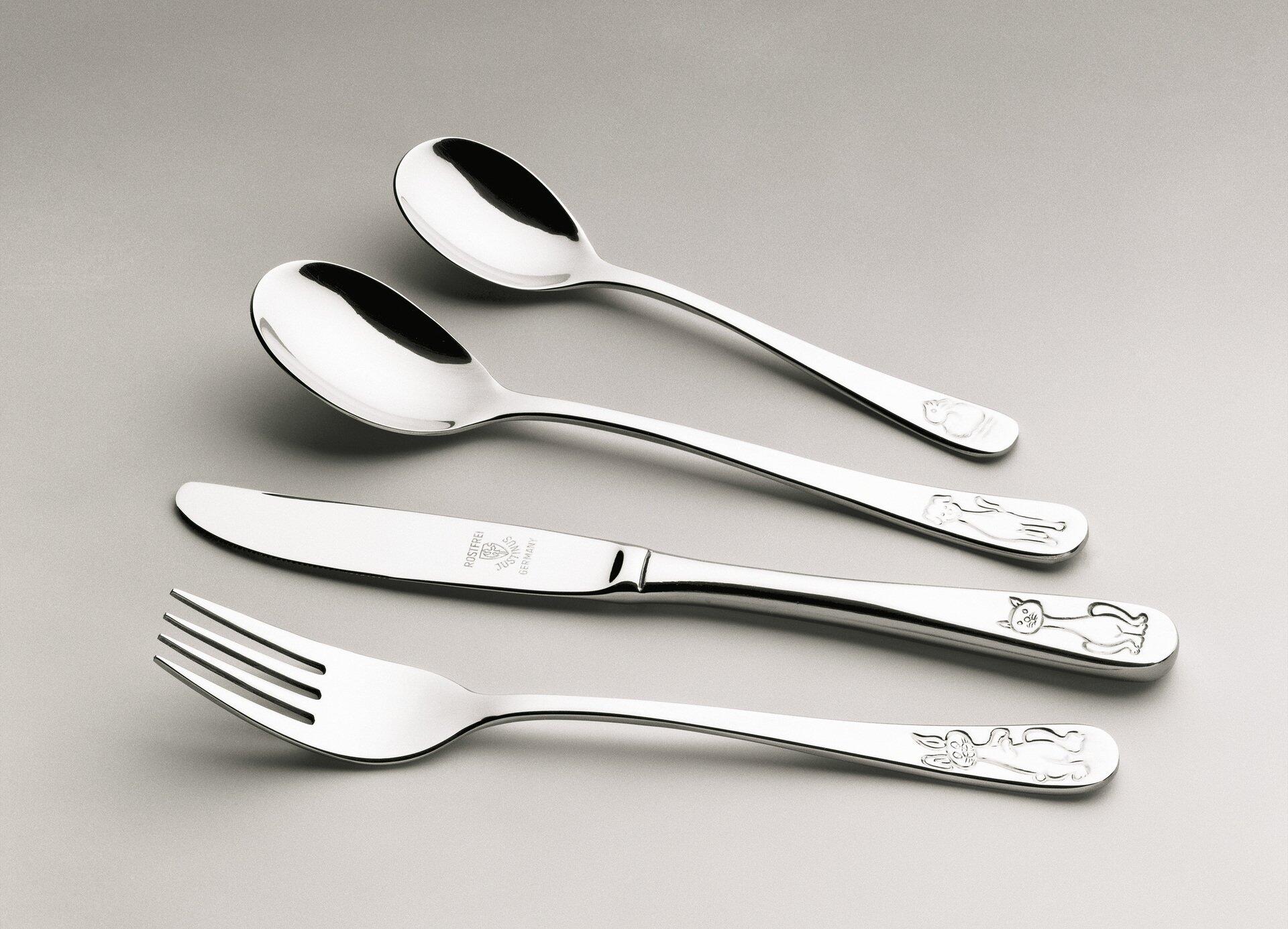Kinderbesteck "Meine Tiere" mit Gabel, Esslöffel, Dessertlöffel und Messer mit tierischen Motiven am Griff, in einer schrägen Ansicht, die die Form und Details des Edelstahl-Bestecs zeigt.