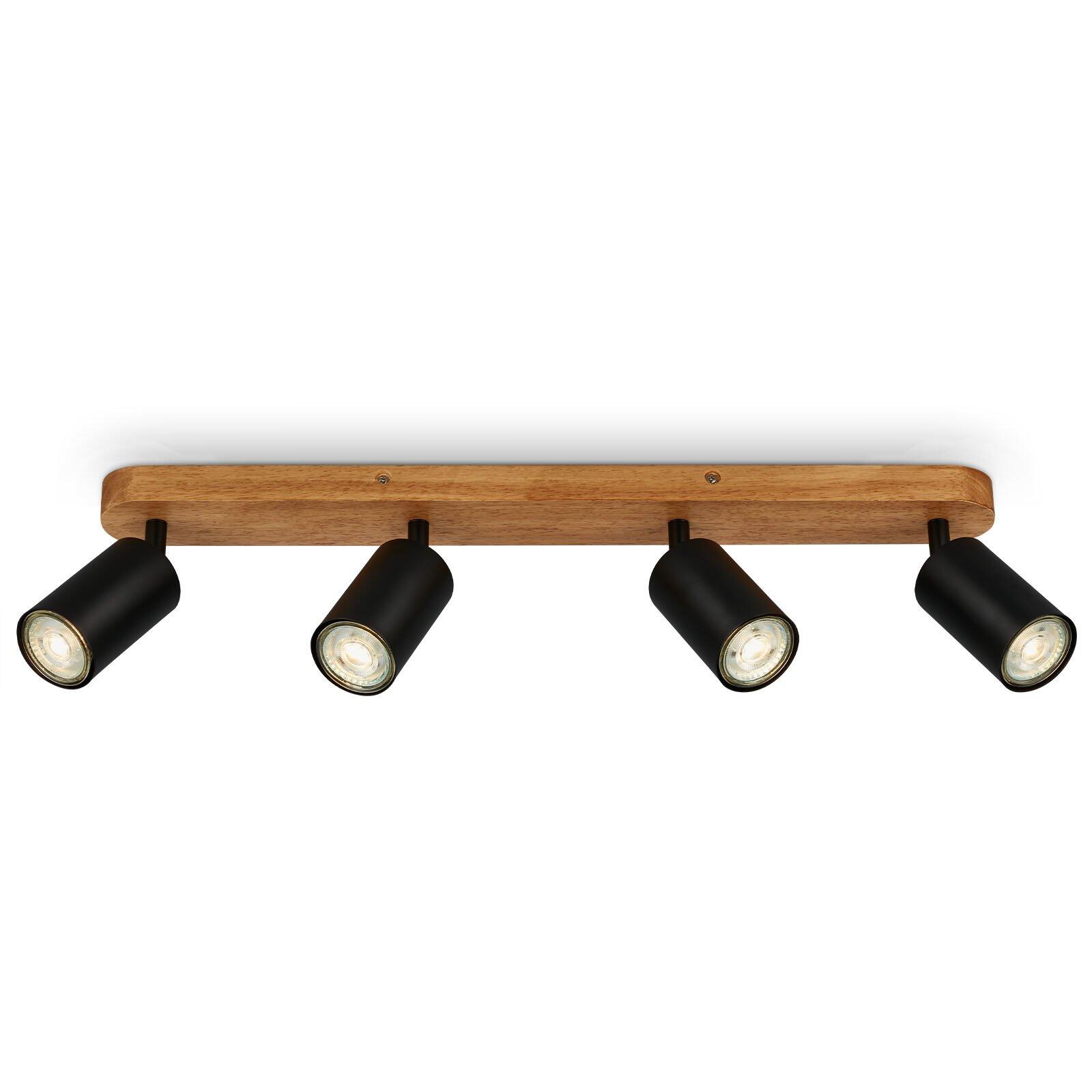 Moderne Deckenleuchte Spot Kullig mit vier beweglichen, schwarzen Lampenköpfen an einem helifarbenen Holzbalken, die ein gerichtetes, warmweißes Licht abgeben.
