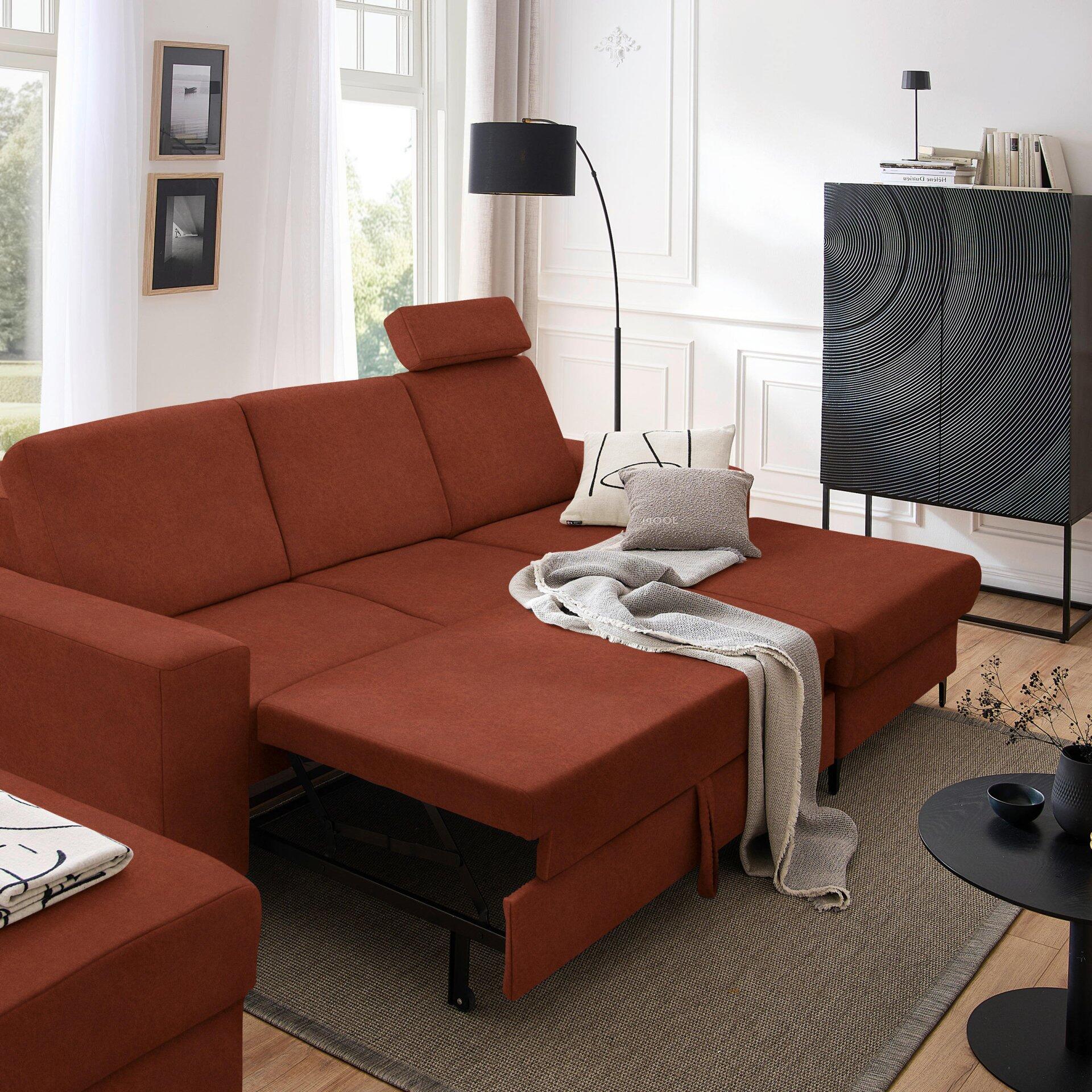 Rotbraunes Ecksofa Balina mit ausgezogener Schlaffläche und Winkelfüßen, detailliert aus erhöhter Perspektive mit angrenzendem Raum und Dekorationselementen.