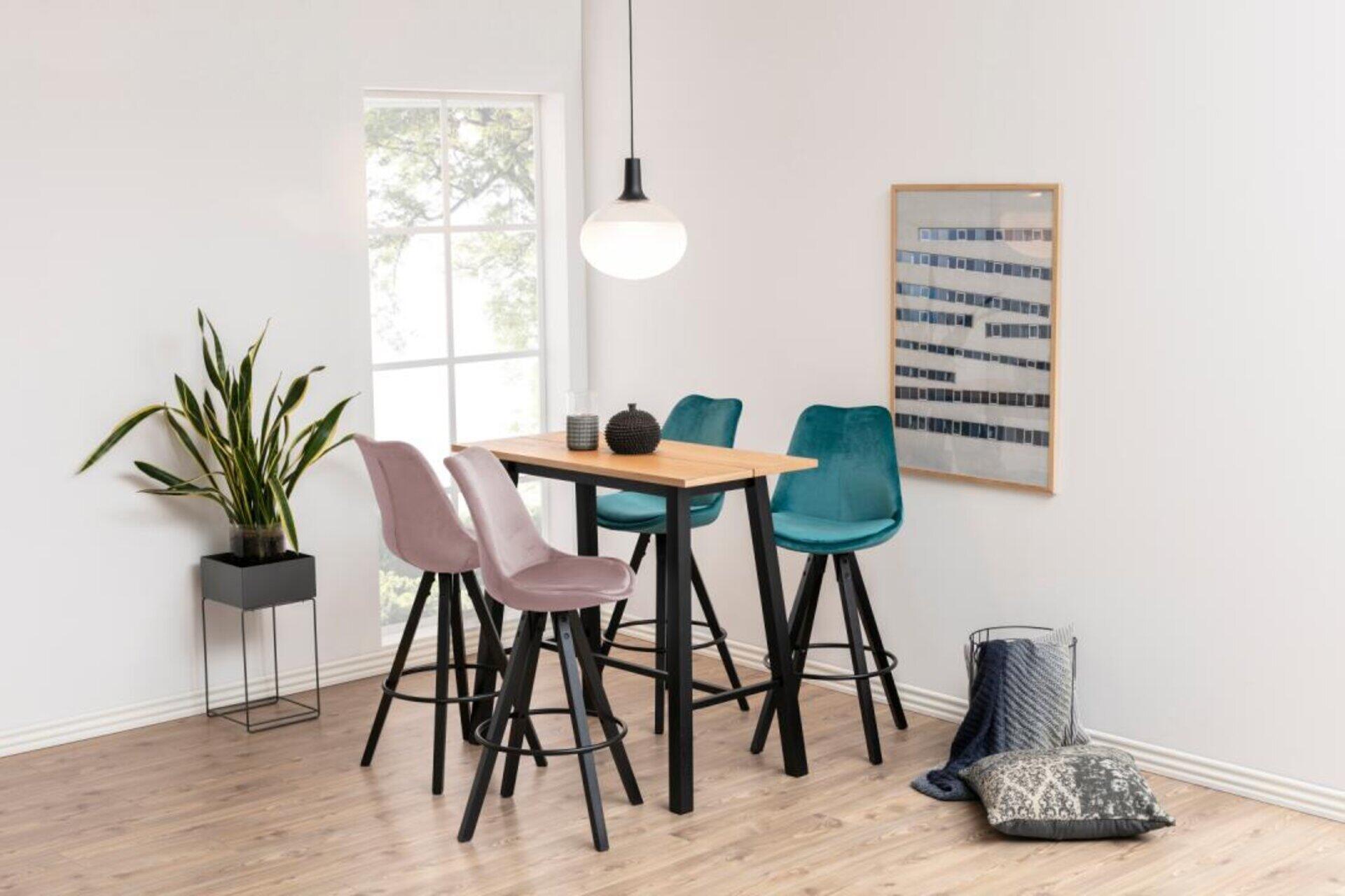Bartisch Chara mit Splittop-Optik und passenden Barhockern in Rosa- und Türkis-Velours sowie schwarzen Metallbeinen, aus erhöhter Perspektive in einem stilvollen Essbereich.
