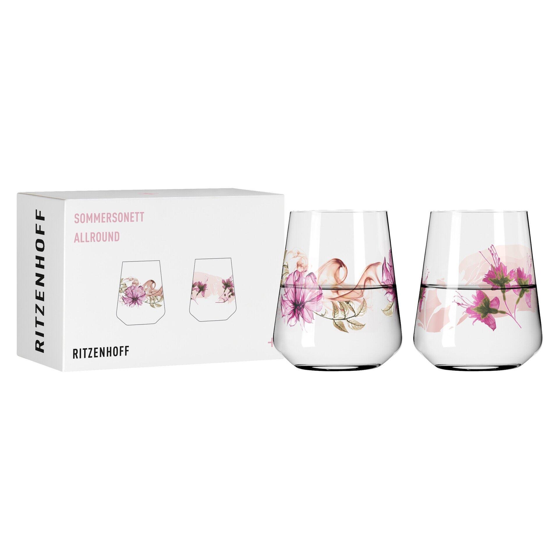 Zwei konische Aperitifgläser aus Glas mit floralem Rosa-Lila-Design aus dem 2-teiligen Universalglas-Set "SOMMERSETT ALLROUND" von RITZENHOFF, zusammen mit der Geschenkverpackung.