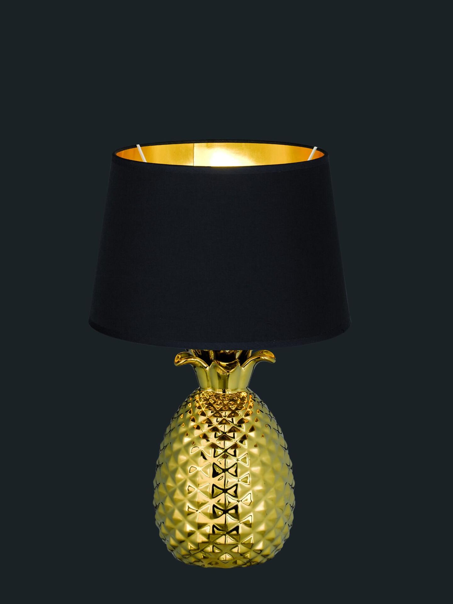 Tischleuchte Pineapple mit goldenem Ananas-Körper und kegelförmigem Lampenschirm, die im ¾-Profil einen detailreichen, glänzend strukturierten Lampenfuß zeigt.