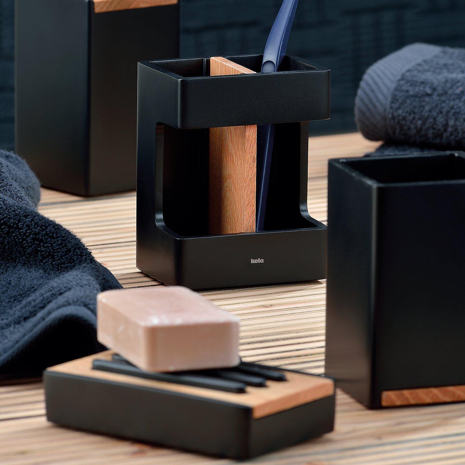 Zahnbürstenhalter Cube in Schwarz mit Holzapplikationen, detailliert auf einem Holzrost mit weiteren Accessoires gezeigt.
