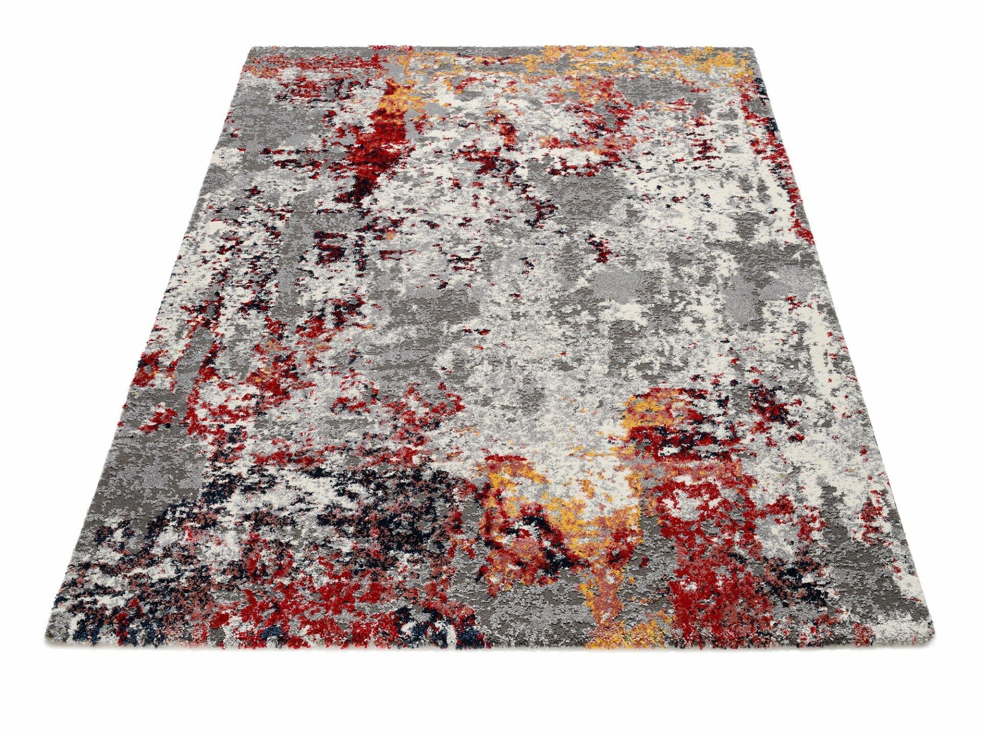 Maschinenwebteppich Kalmira mit abstraktem Design in Grau, Rot, Orange, Gelb und Blau, aus der Vogelperspektive sichtbar.