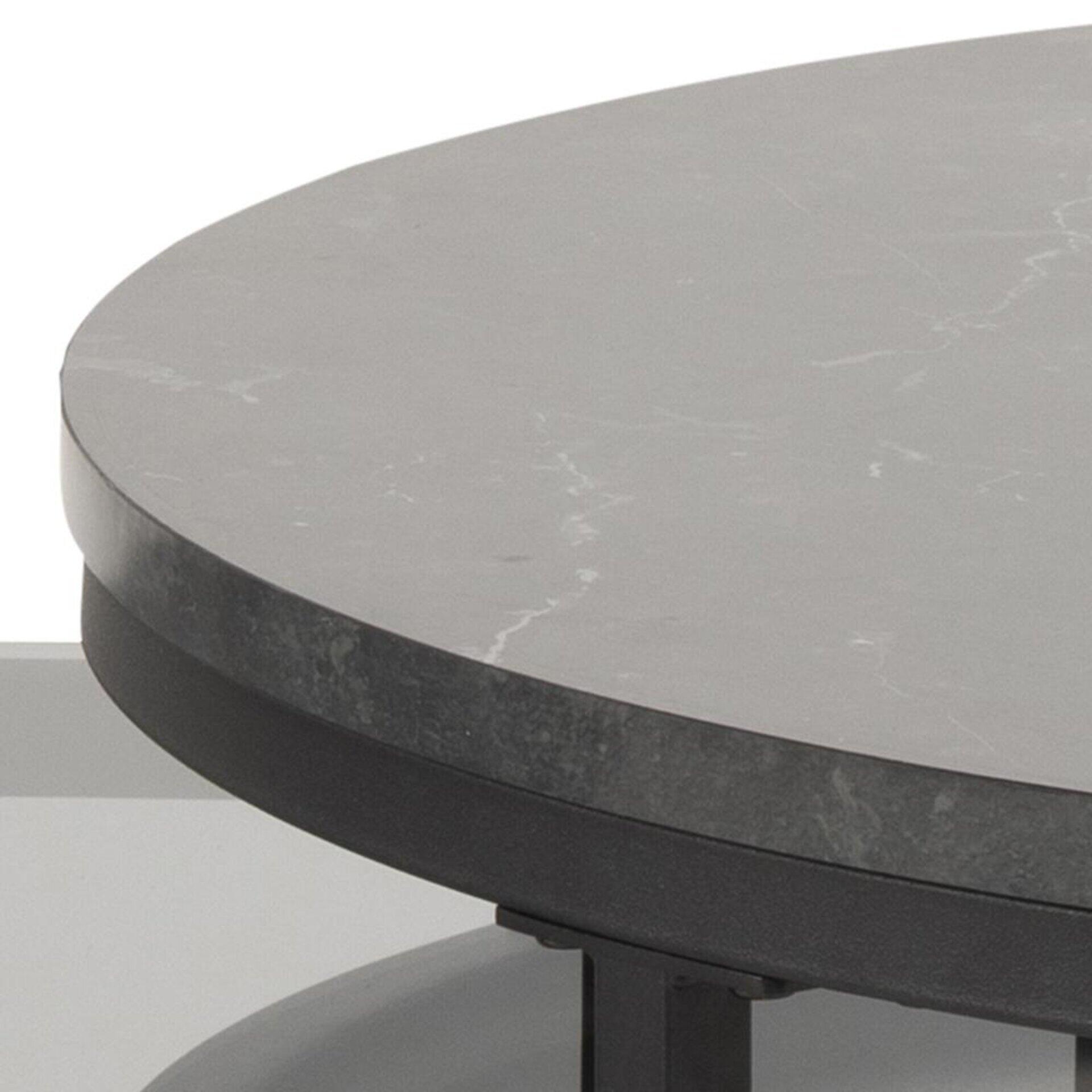 Detailaufnahme des Couchtisches Spiro: Runde Marmorplatte mit grauer Grundfarbe und weißen Adern, umgeben von einem schwarzen Metallrahmen.