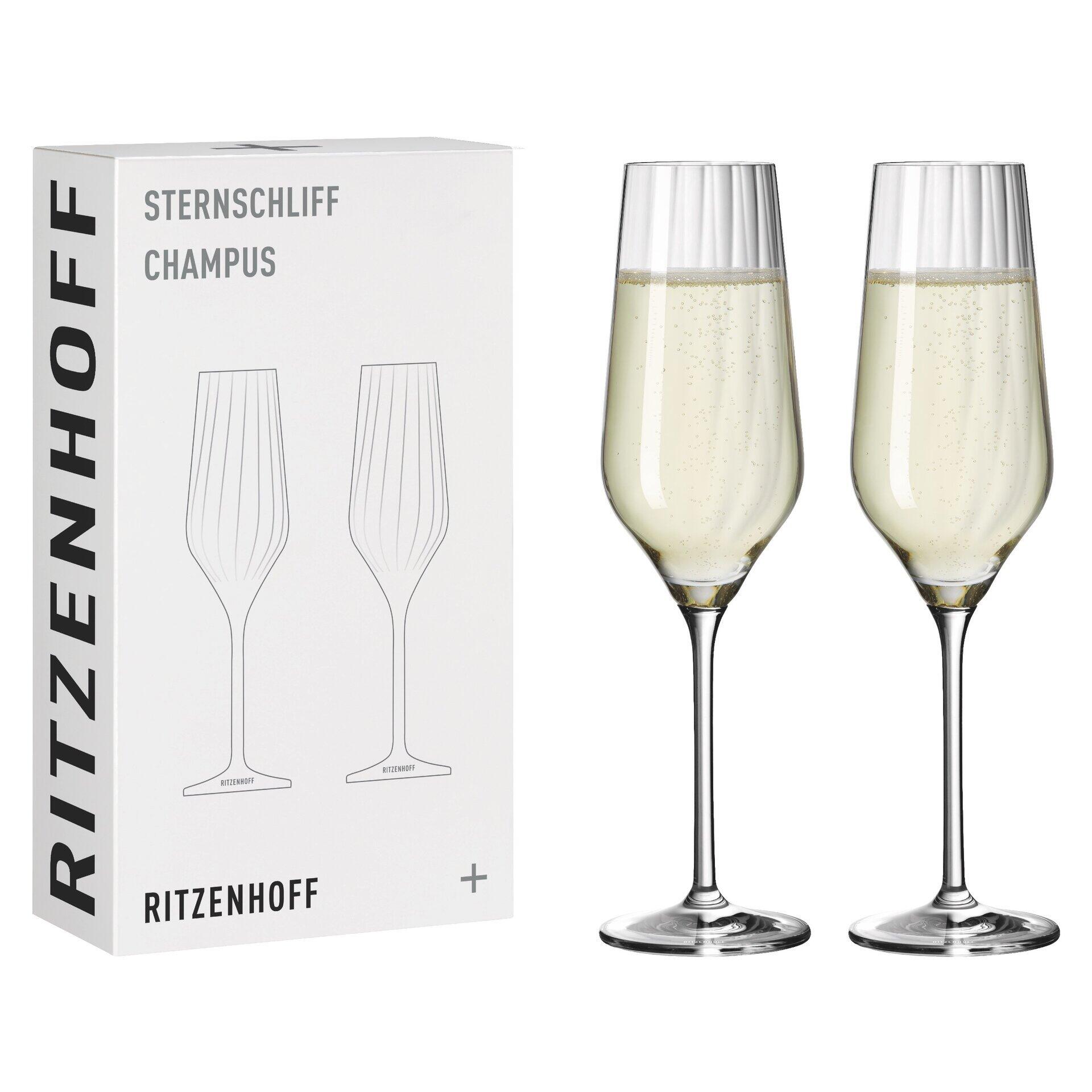 Zwei elegante Champagnergläser mit Sternschliff-Reliefstruktur, teilweise mit Champagner gefüllt, zusammen mit der Geschenkbox des Champusglas-Sets von RITZENHOFF.