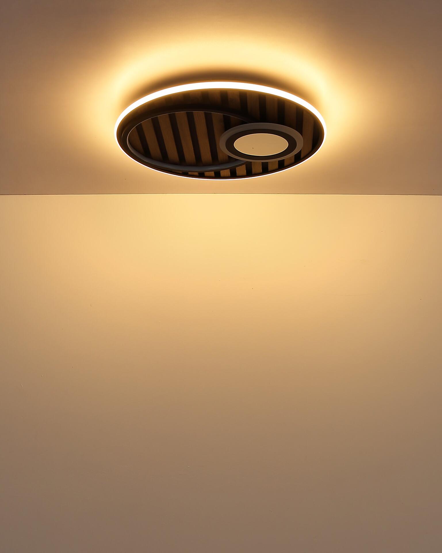 Deckenleuchte WOODY mit mehreren LED-Ringen, die aus einer schrägen Frontalperspektive die Designelemente und das sanfte, diffuse Licht zeigen.