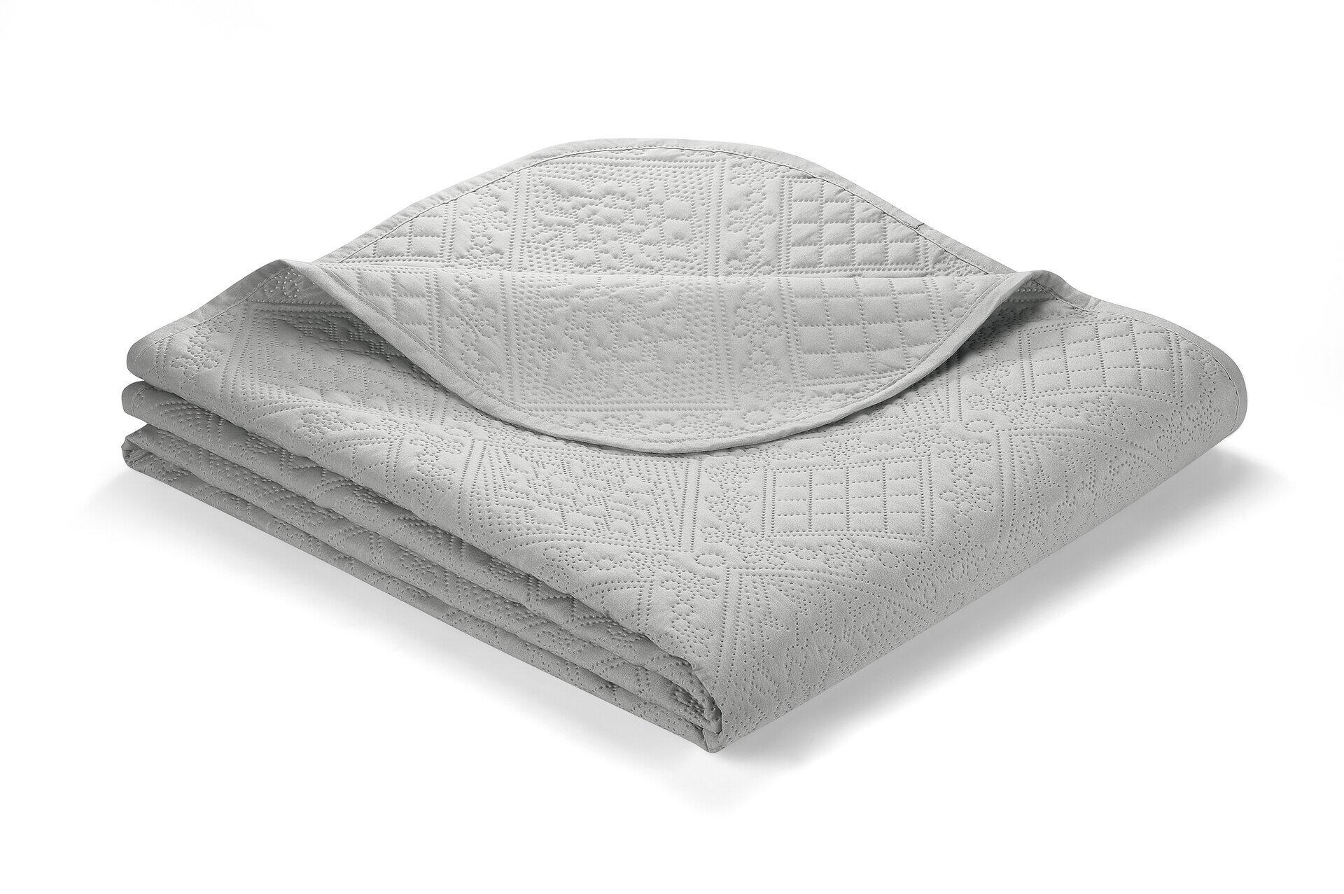 Silbergraue Patchwork-Steppdecke Nancy aus Polyester mit geometrischen Mustern, die die Textur und das Design der Steppung zeigen.
