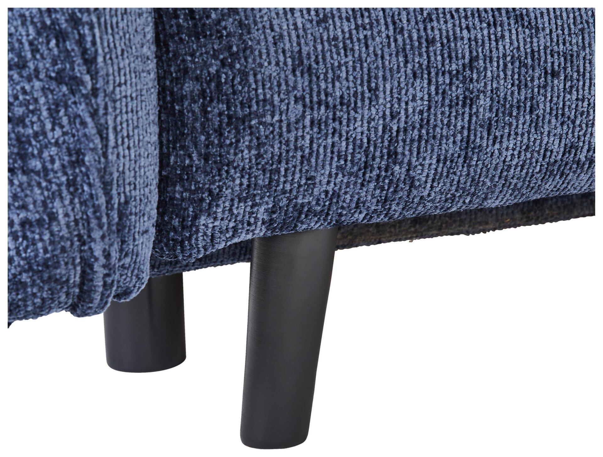 Nahaufnahme des blauen Samtsofas Santana mit konischen, schwarzen Holzfüßen und strukturierter Samtbezogenheit der Rückenlehne.
