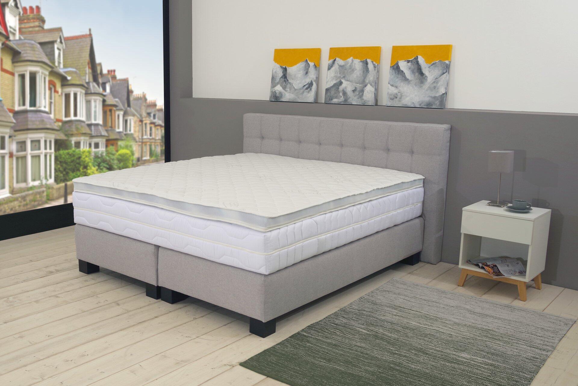 Topper G100 auf einem hellgrauen Boxspringbett mit gestepptem Diamantmuster und umlaufendem Klimaband.