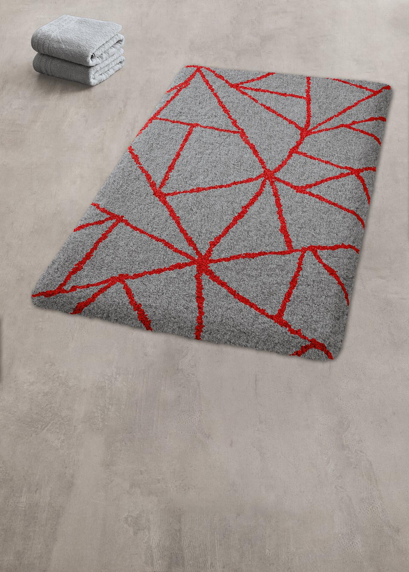 Grauer Badteppich Bondi mit auffälligem, geometrischem Rot-Design aus scharfkantigen Linien und Dreiecken.