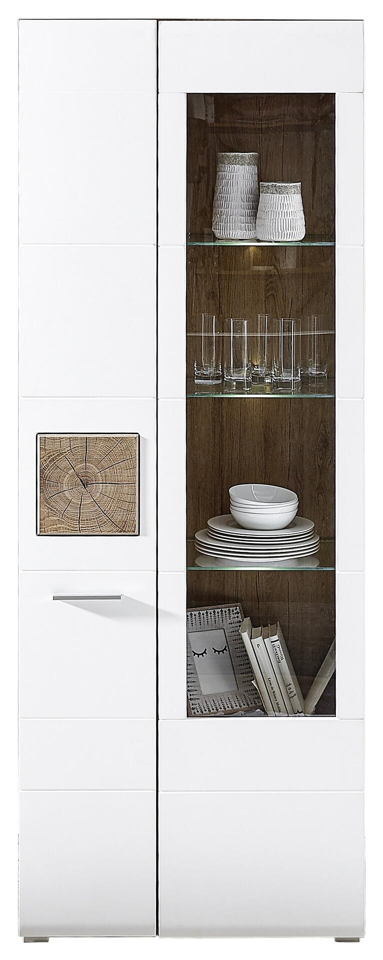 Vitrine Savona mit weißen Lacklaminatfronten, Glastüren und Holztür mit Baumstumpf-Muster, zeigt dekorative Elemente auf den Regalböden und beleuchtetes Innenleben.