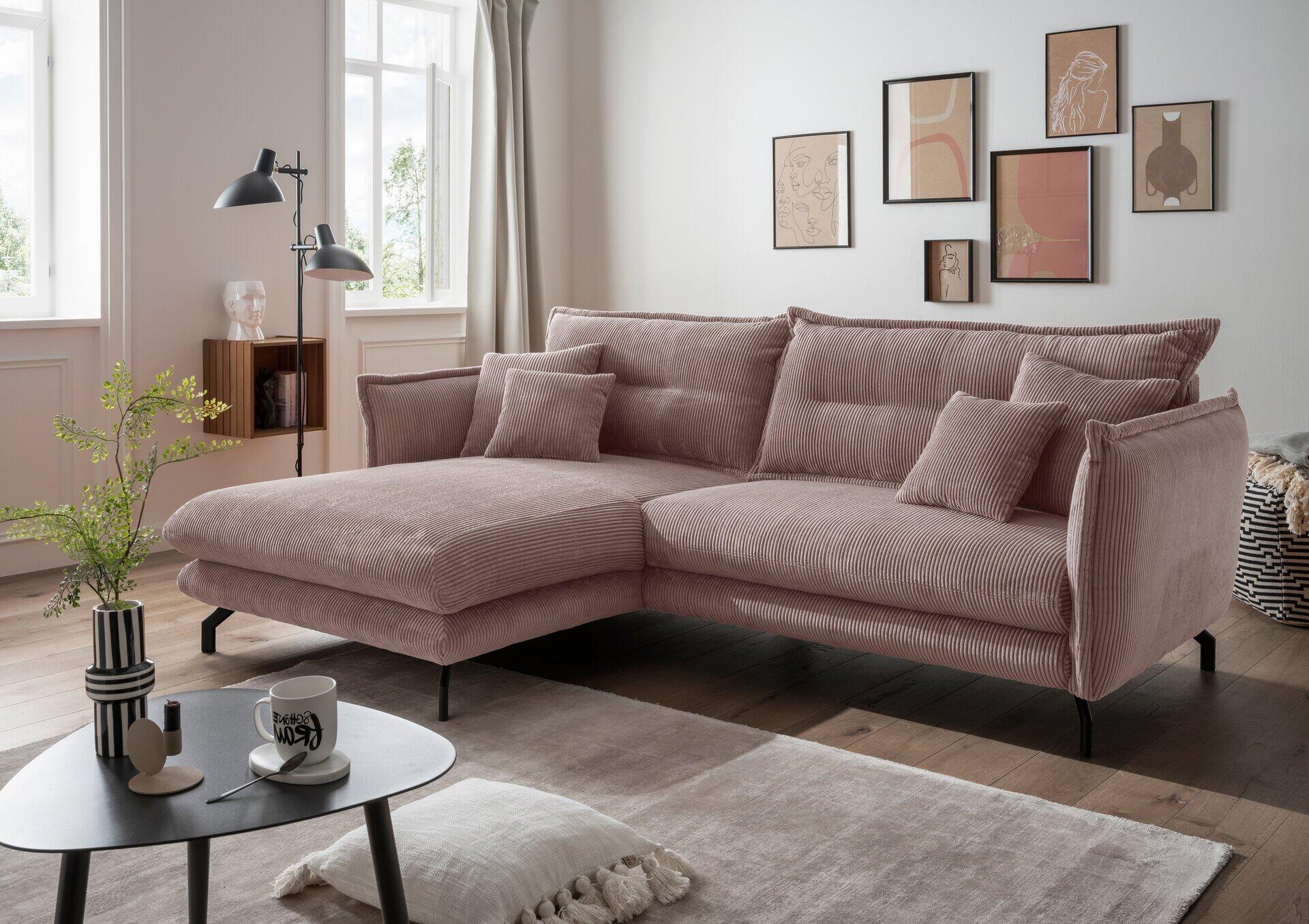 Gemütliches Ecksofa Lava in Rosé mit Winkelfüßen aus Metall, abgebildet aus leicht seitlicher Perspektive, zeigt die hohe Rückenlehne und üppigen Sitzkissen in einer stilvollen Wohnsituation.