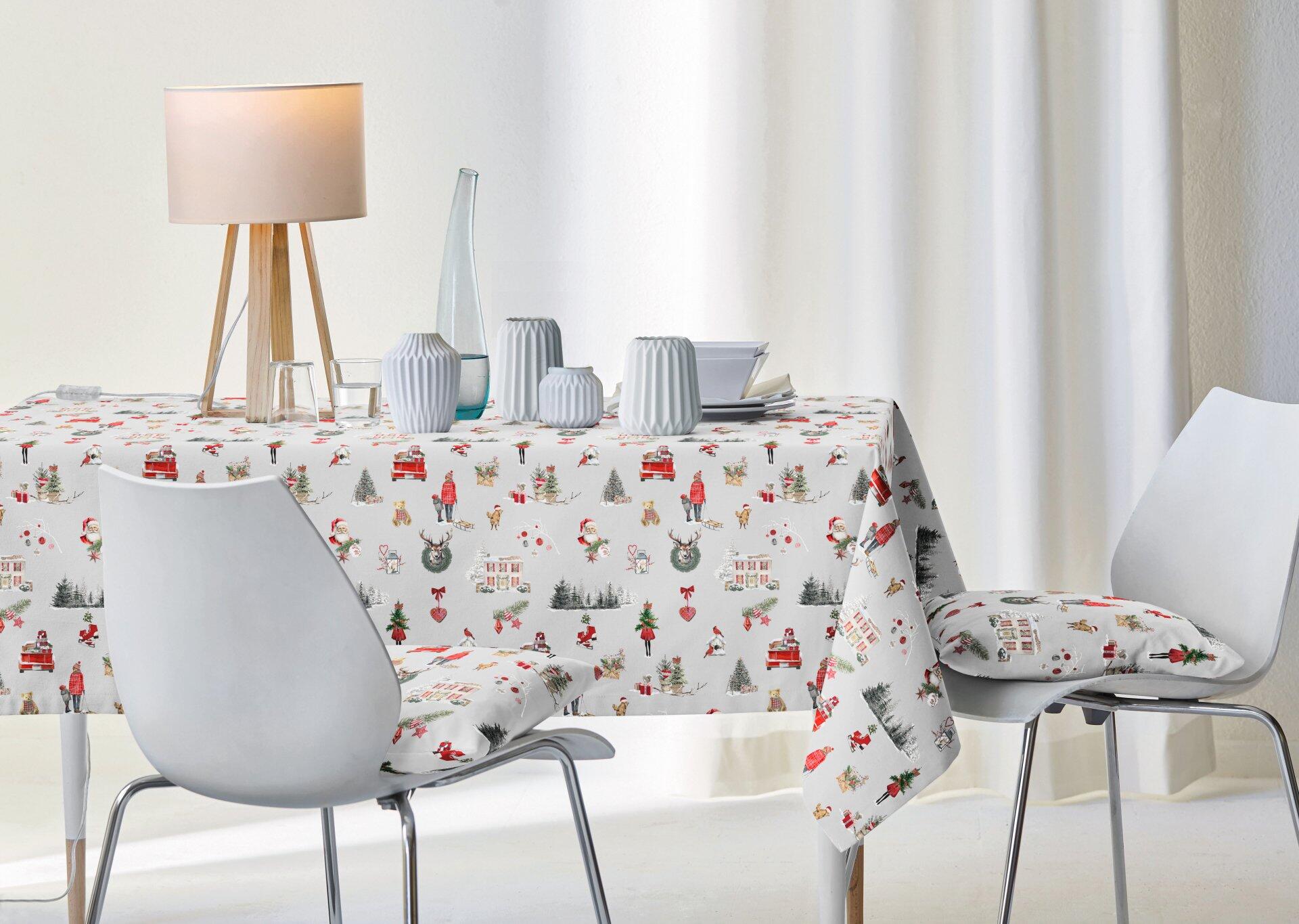 Festlich gedeckter Tisch mit grau-roter Tischdecke "Christmas All-Over" und Winterwelt-Motiv, detailliert aus leicht schräger Perspektive abgebildet.