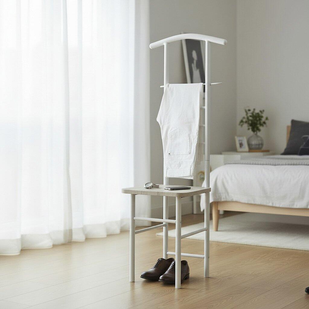 Weiß lackierter Herrendiener aus Stahlrohr mit Kleiderbügel, zusätzlicher Hängeleiste, Ablagefläche für Accessoires und Schuhablage, leicht in Perspektive aufgenommen.