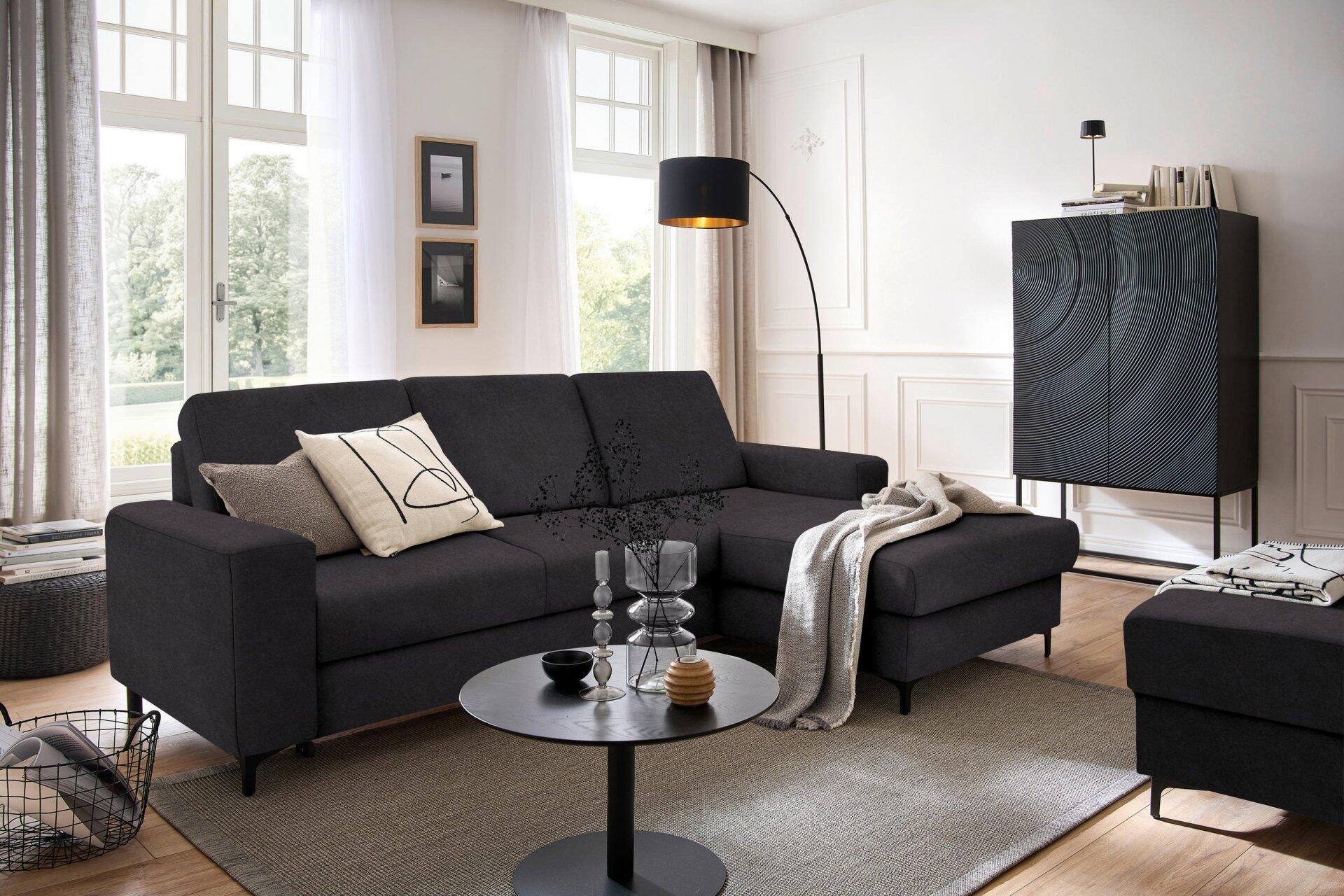 Ecksofa Balina mit Ottomane, hochgeklapptem Fußteil und schwarzen Metallfüßen, abgebildet aus leicht erhöhter Seitenperspektive.