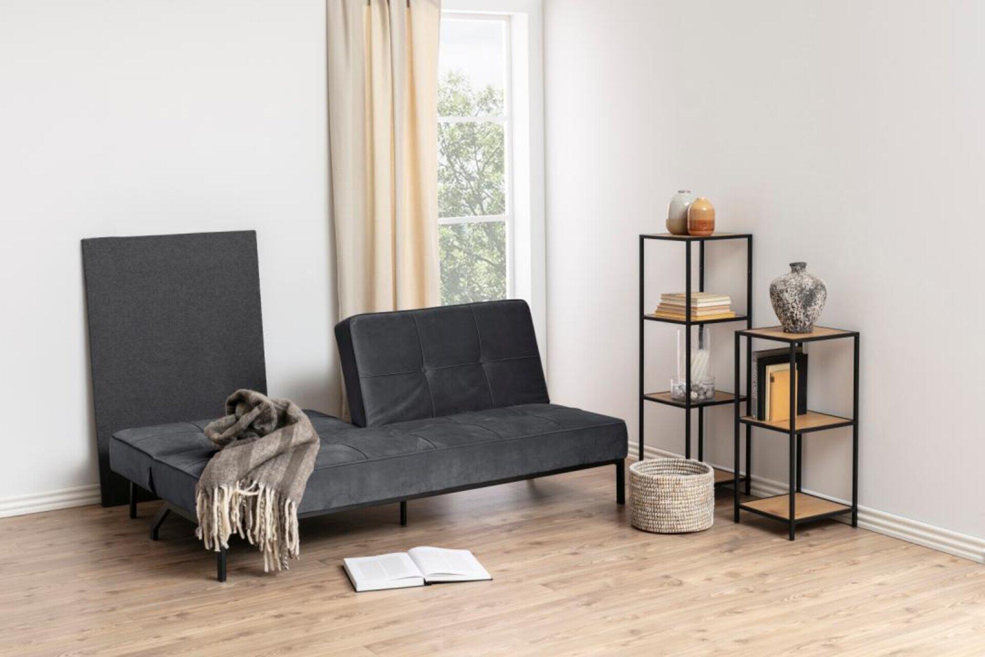 Schlafcouch Perugia mit niedrigem Sitz, schlanken Metallbeinen und grob gestricktem Überwurf in einer minimalistischen Einrichtung.