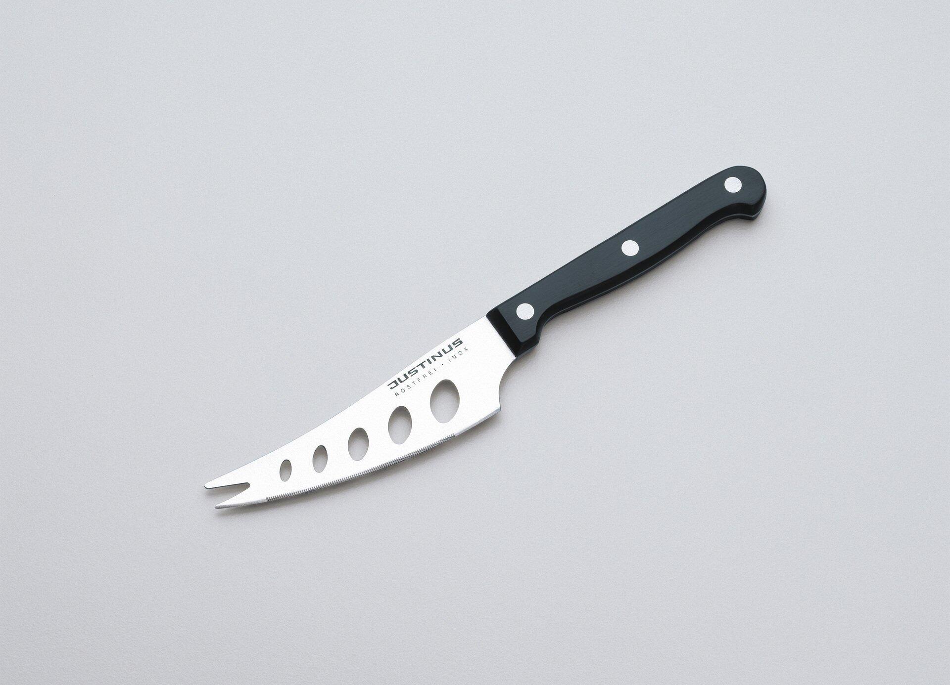 Käsemesser Küchenchef mit Edelstahlklinge und Bakelitgriff, aus der Frontalperspektive schräg zur Schneide geneigt dargestellt, wobei die kreisförmigen Löcher und die abgerundete Spitze erkennbar sind.