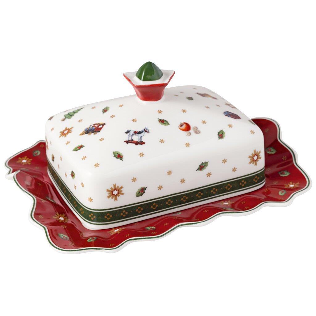 Weihnachtliche Butterdose Toy's Delight von Villeroy & Boch mit rotem Deckel und feststellbarem Deckel, dargestellt in einer Draufsicht auf einer roten Servierplatte mit goldenen Sternen.