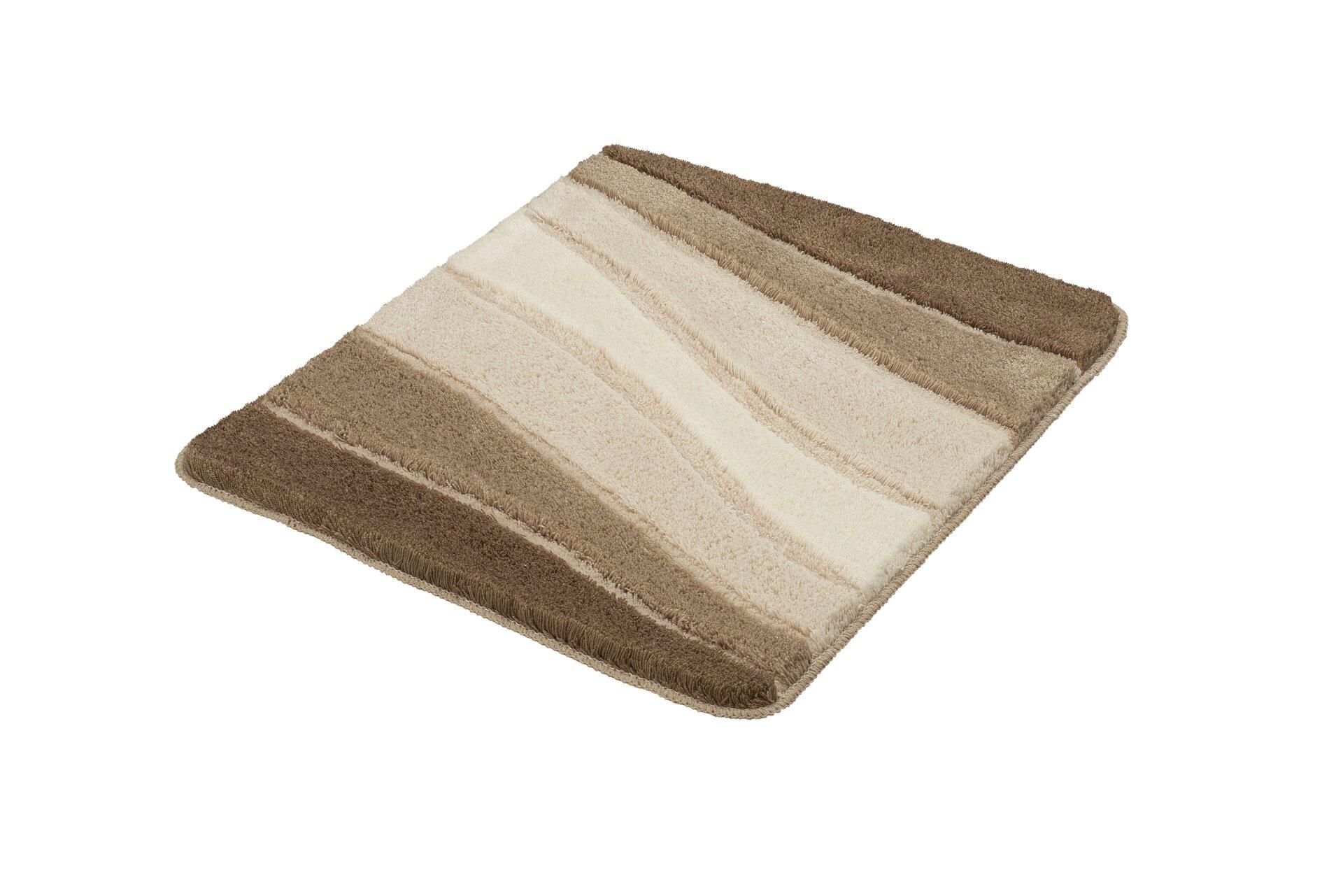 Badteppich Ocean in Taupe mit gewellter, flauschiger Oberfläche und abgerundeten Kanten auf weißem Untergrund.